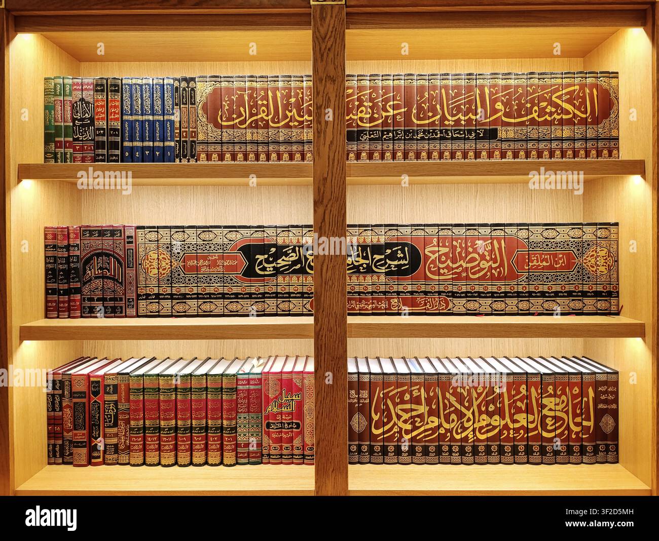 Bibliothèque islamique dans un style créatif avec des étagères illuminées remplies de livres en arabe Banque D'Images