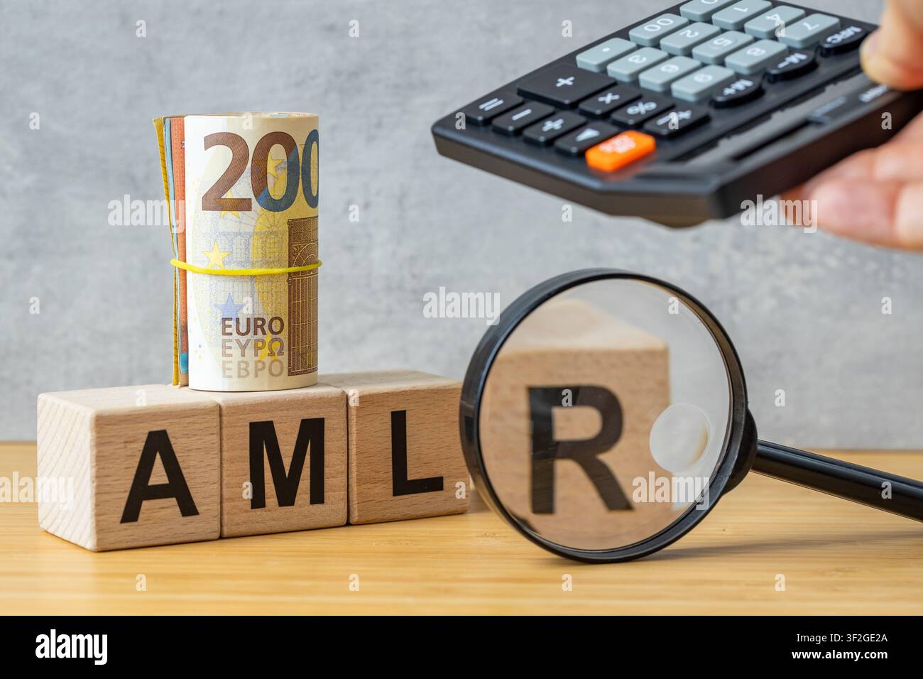Concept AMLR 2027. Règlement Anti-Blanchiment d'Argent, symbole AMLR sur des cubes en bois, rouleau de billets en euros, loupe et calculatrice. Nouvelle EU fina Banque D'Images