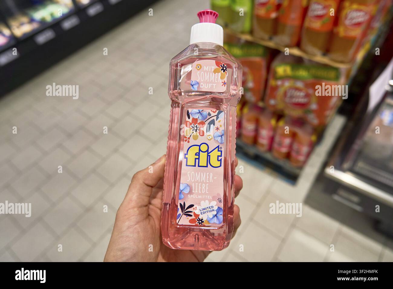 Main montrant une bouteille de liquide vaisselle de la marque Fit au parfum d'été sur l'étagère d'un supermarché, discount alimentaire Penny Banque D'Images