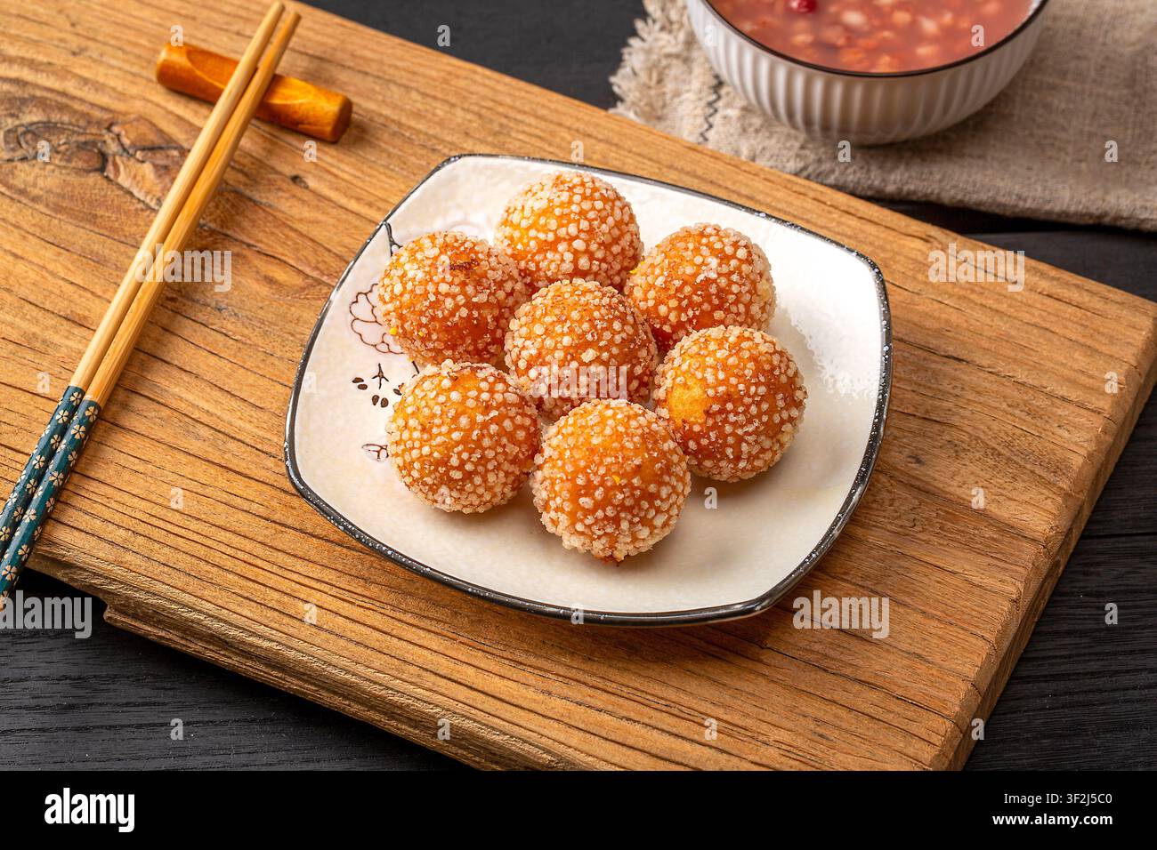 Boules de sésame frites avec une garniture de lait de coco fondu sucré Banque D'Images