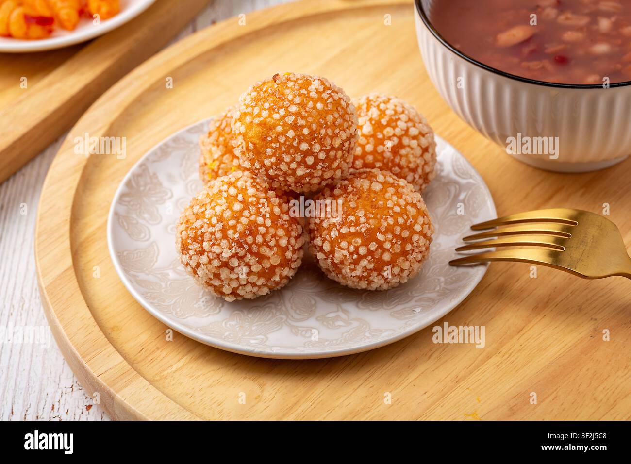 Boules de sésame frites avec une garniture de lait de coco fondu sucré Banque D'Images