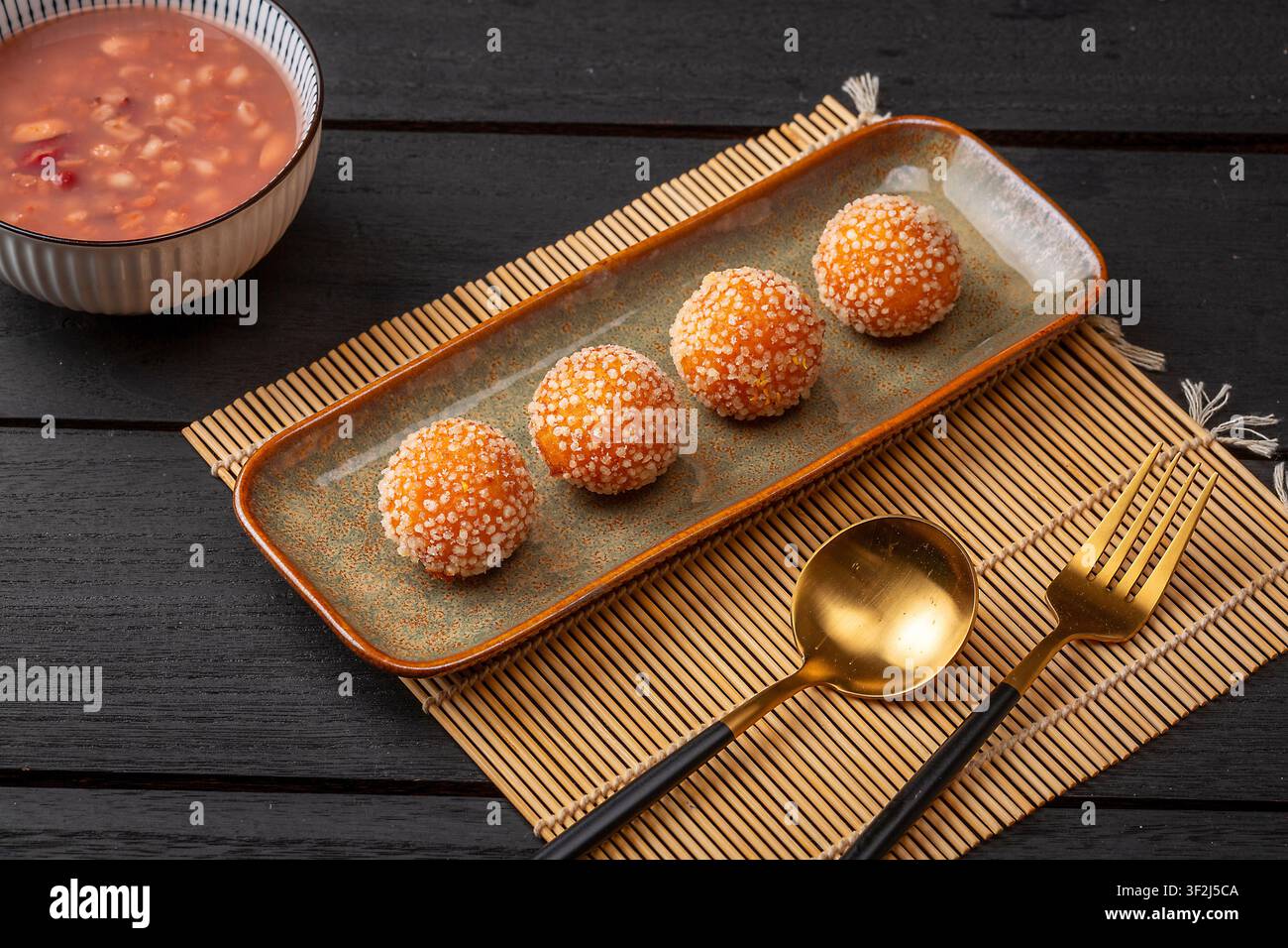 Boules de sésame frites avec une garniture de lait de coco fondu sucré Banque D'Images