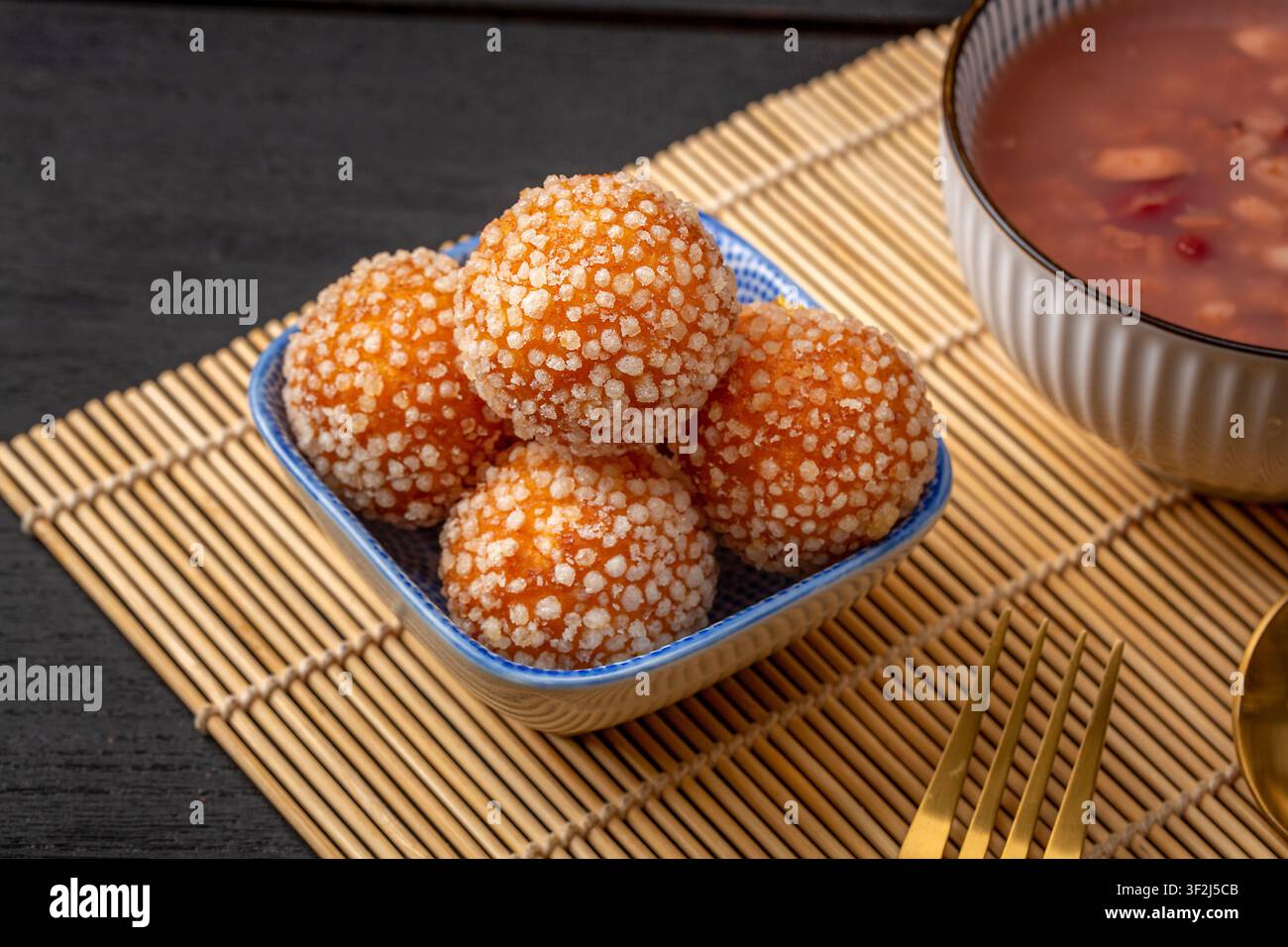 Boules de sésame frites avec une garniture de lait de coco fondu sucré Banque D'Images
