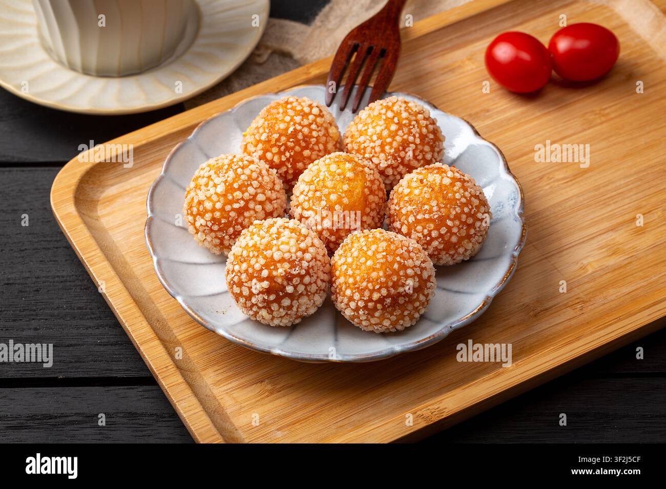 Boules de sésame frites avec une garniture de lait de coco fondu sucré Banque D'Images