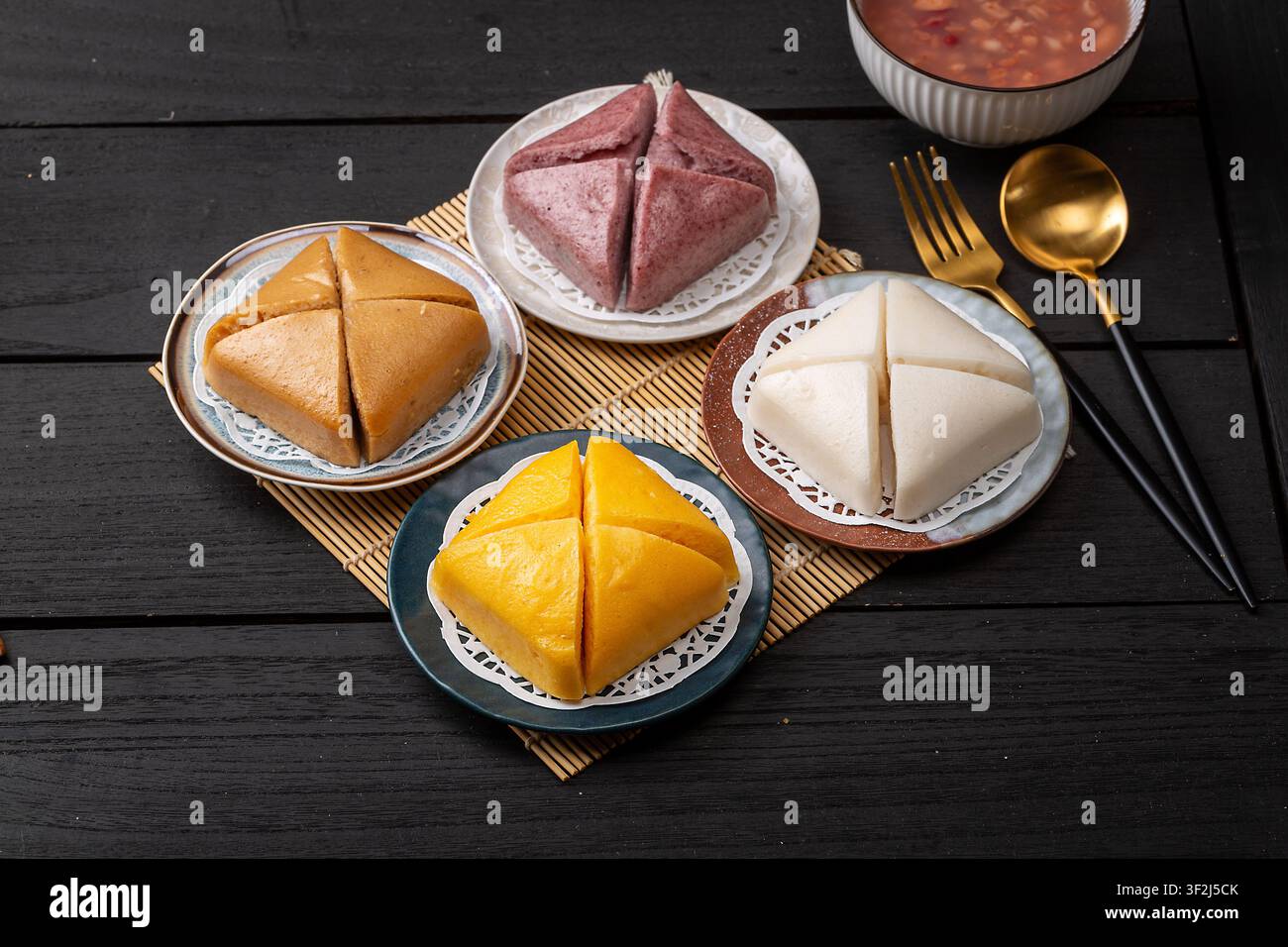 Quatre gâteaux de riz cuits à la vapeur traditionnels assortis portant bonheur et multicolores Banque D'Images