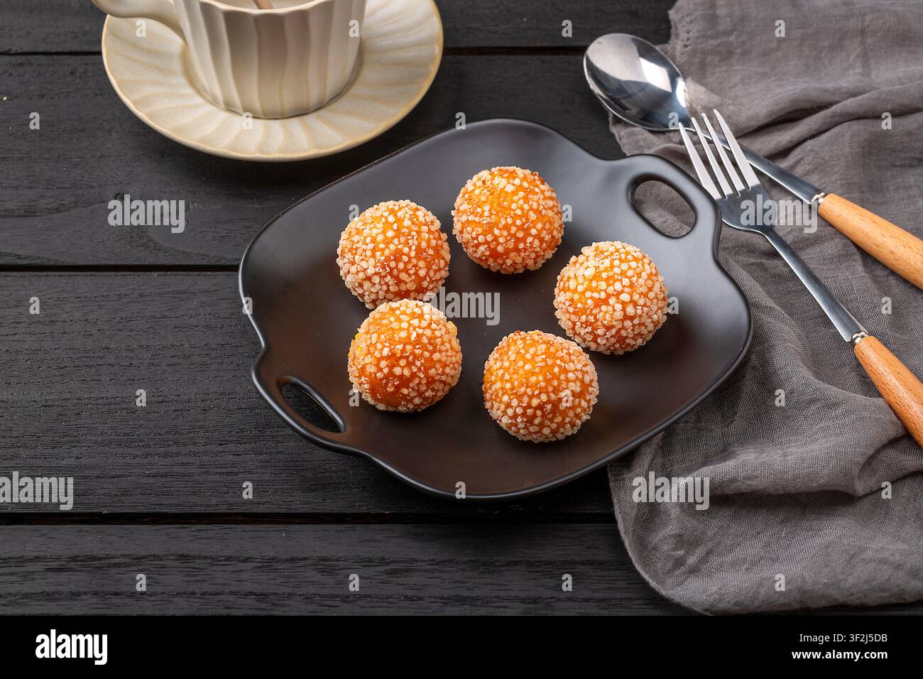 Boules de sésame frites avec une garniture de lait de coco fondu sucré Banque D'Images