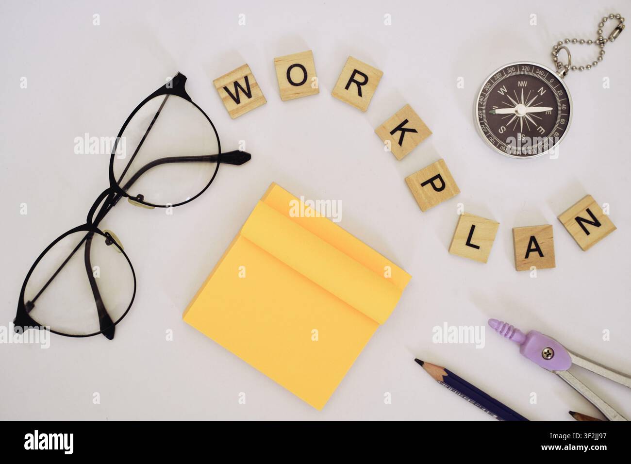 Lettres en bois épelant plan de travail avec une boussole et des lunettes. Banque D'Images