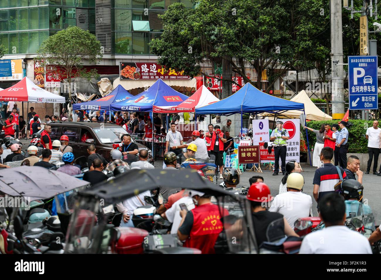 (260719) -- CHONGQING, 19 juillet 2026 (Xinhua) -- Des bénévoles à moto attendent en file à un point de rassemblement pour livrer des fournitures et du personnel dans le comté autonome Miao et Tujia de Pengshui à Chongqing, dans le sud-ouest de la Chine, le 19 juillet 2026. Un éboulement induit par les pluies s'est produit à 9 h 08 vendredi dans le sous-district de Hanjia à Pengshui, ensevelissant plus de 10 bâtiments résidentiels, laissant certains résidents locaux piégés et portés disparus. La Chine a activé une réponse d'urgence nationale de niveau II pour les catastrophes géologiques. Plusieurs forces de secours, y compris la réponse d'urgence, la lutte contre les incendies et Banque D'Images