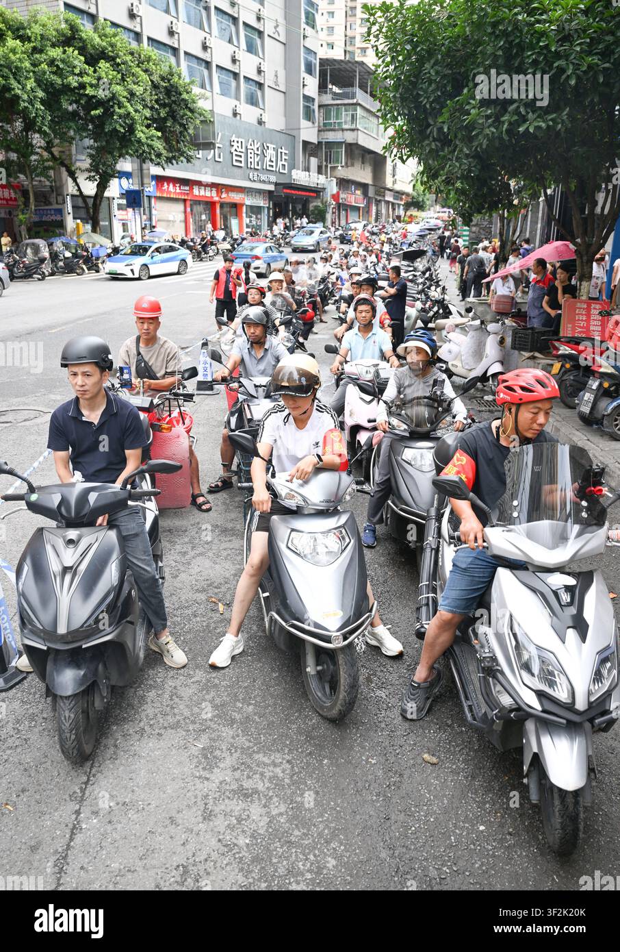 (260719) -- CHONGQING, 19 juillet 2026 (Xinhua) -- Des bénévoles à moto attendent en file à un point de rassemblement pour livrer des fournitures et du personnel dans le comté autonome Miao et Tujia de Pengshui à Chongqing, dans le sud-ouest de la Chine, le 19 juillet 2026. Un éboulement induit par les pluies s'est produit à 9 h 08 vendredi dans le sous-district de Hanjia à Pengshui, ensevelissant plus de 10 bâtiments résidentiels, laissant certains résidents locaux piégés et portés disparus. La Chine a activé une réponse d'urgence nationale de niveau II pour les catastrophes géologiques. Plusieurs forces de secours, y compris la réponse d'urgence, la lutte contre les incendies et Banque D'Images