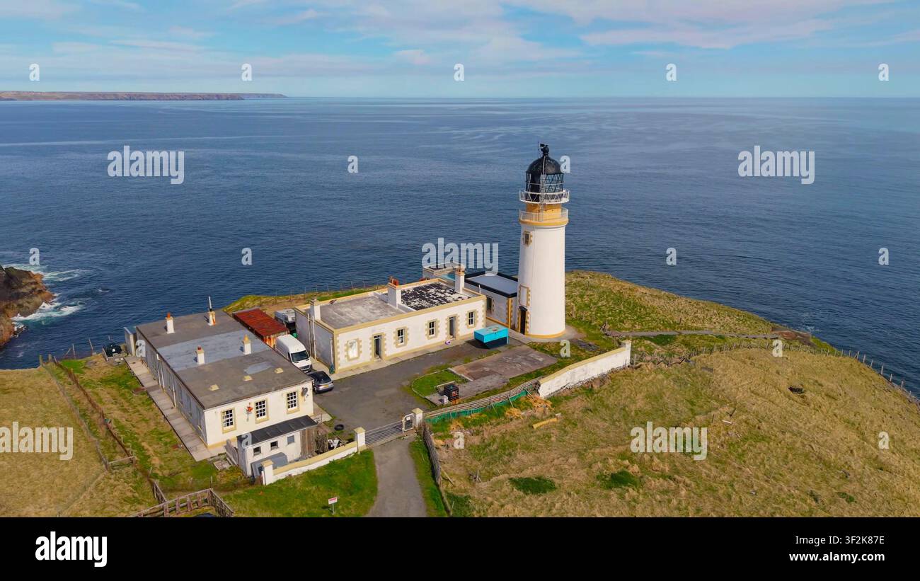 DUNNET HEAD, ÉCOSSE - 12 JUIN 2024 : Un plan en hauteur du phare de Dunnet Head avec les bâtiments blancs adjacents situés sur une colline herbeuse verte surplombant Banque D'Images