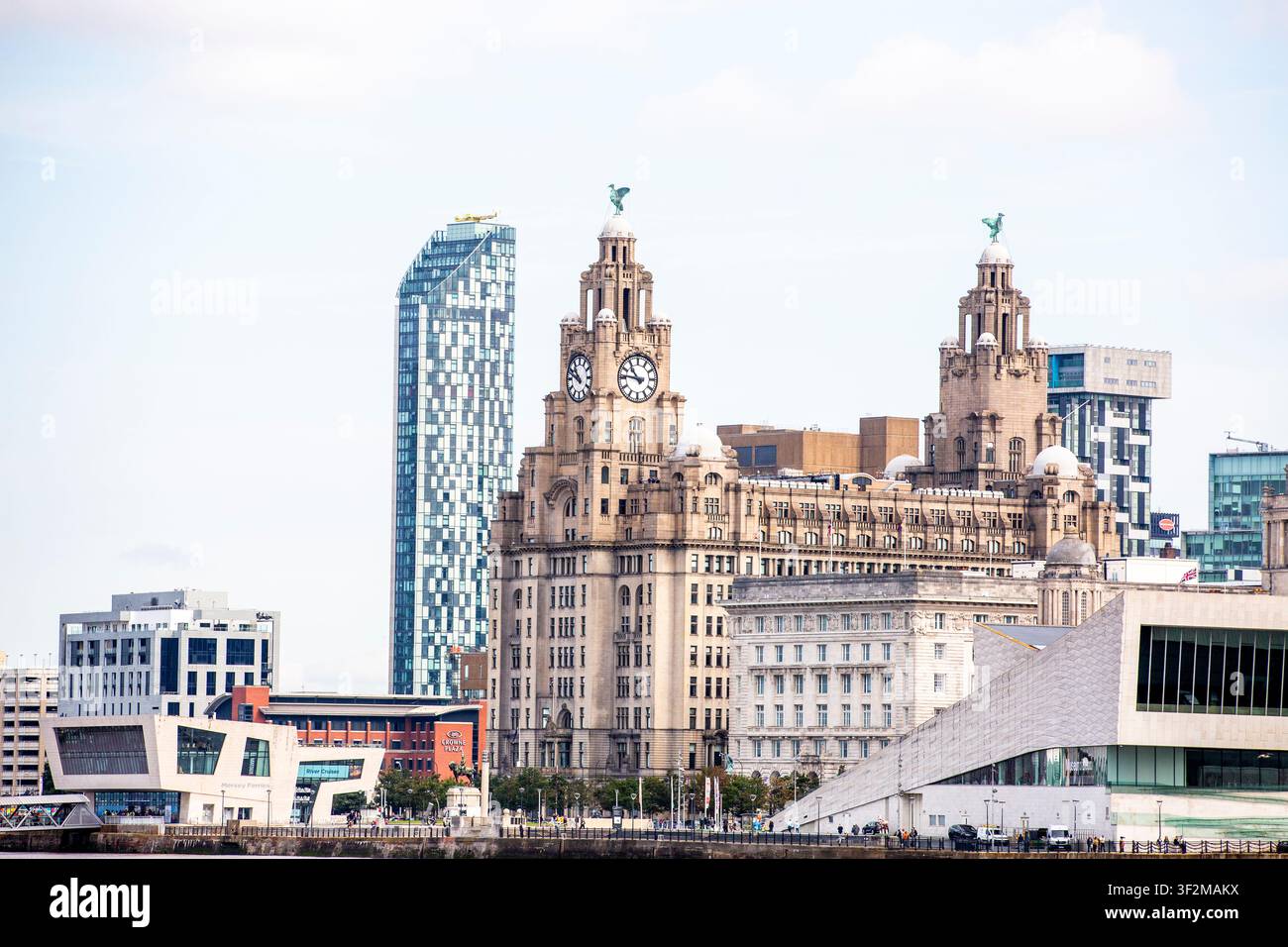 La ligne d'horizon emblématique du front de mer de Liverpool présente une architecture historique et moderne. Le Liver Building se dresse fièrement avec ses deux tours et ses cadrans horaires. Banque D'Images