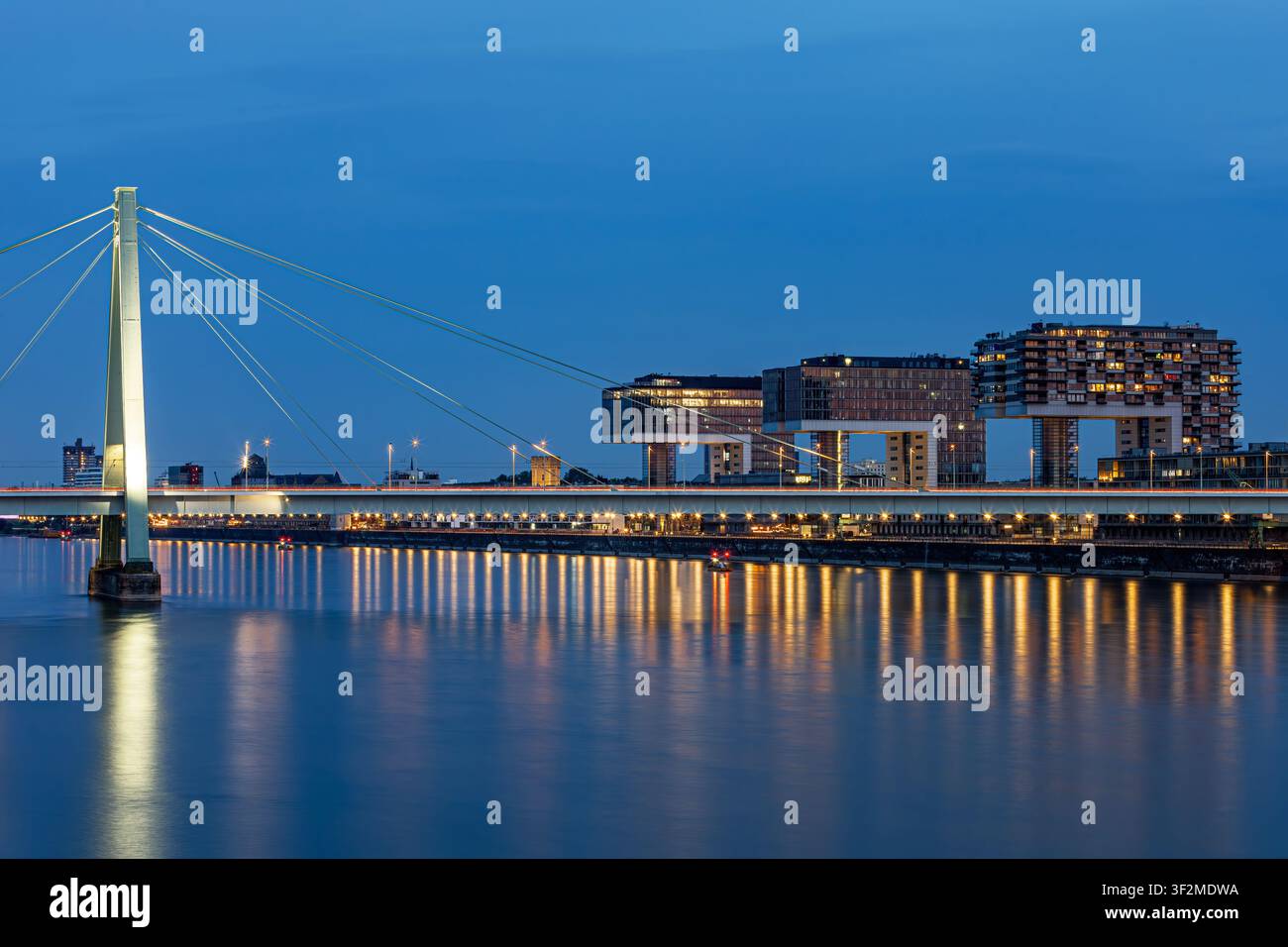 Vue de l'heure bleue de Cologne avec le Rhin, le Rheinauhafen et le pont Severin illuminés contre le ciel du soir. Capturé le 30 mai 2026. Banque D'Images