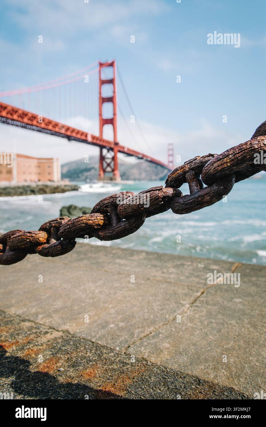Le Golden Gate Bridge vu au-delà d'une chaîne maritime rouillée le long du front de mer de San Francisco en Californie, États-Unis. Banque D'Images