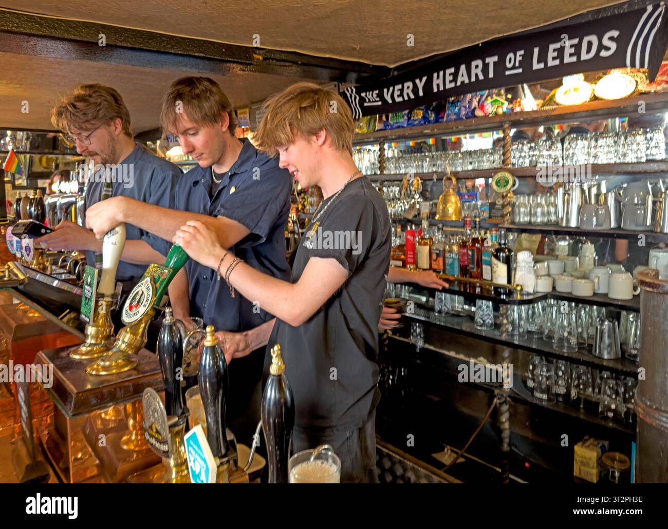 Personnel du bar servant des boissons à l'intérieur du Whitelock's Ale House dans le centre-ville de Leeds, West Yorkshire, Angleterre, Royaume-Uni. Banque D'Images