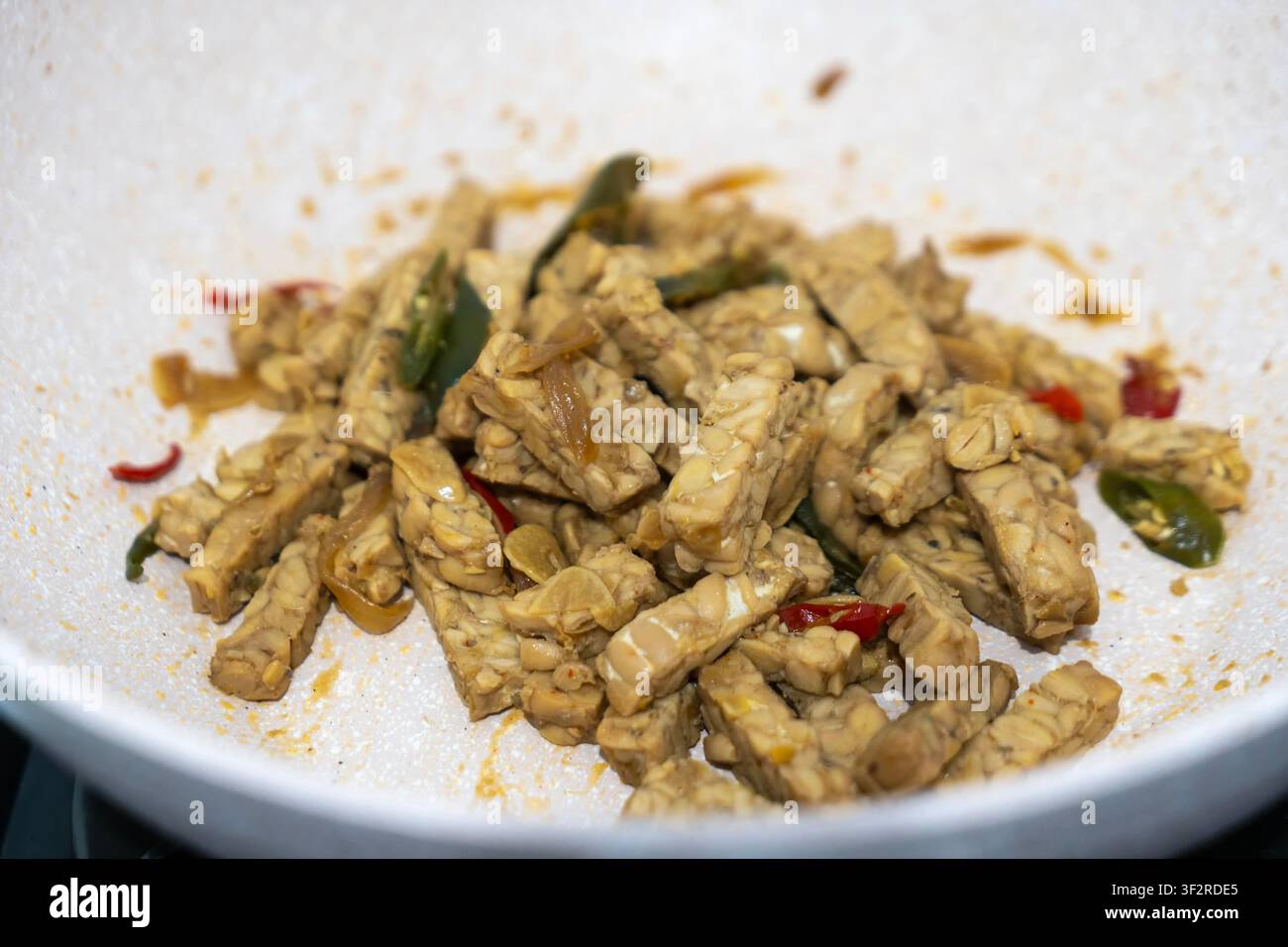 cuire du tempe ou du tempeh dans la poêle Banque D'Images