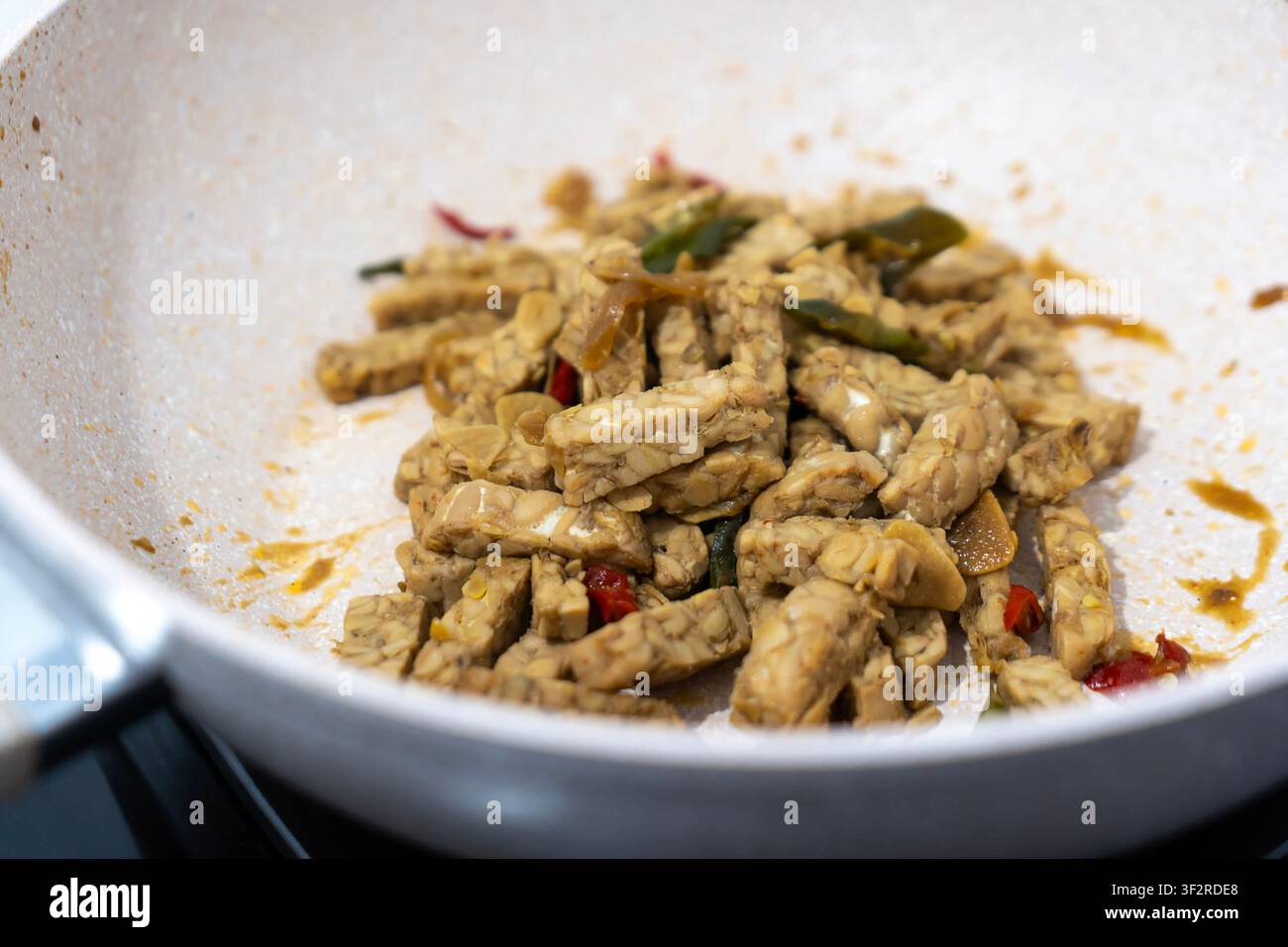 cuire du tempe ou du tempeh dans la poêle Banque D'Images