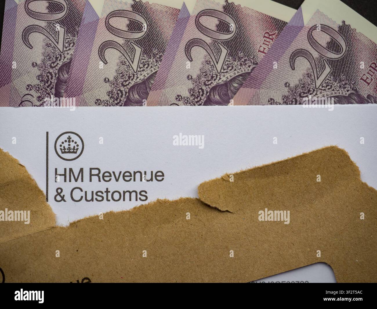 Lettre de HM Revenue Customs avec une enveloppe brune déchirée et vingt livres sterling Banque D'Images