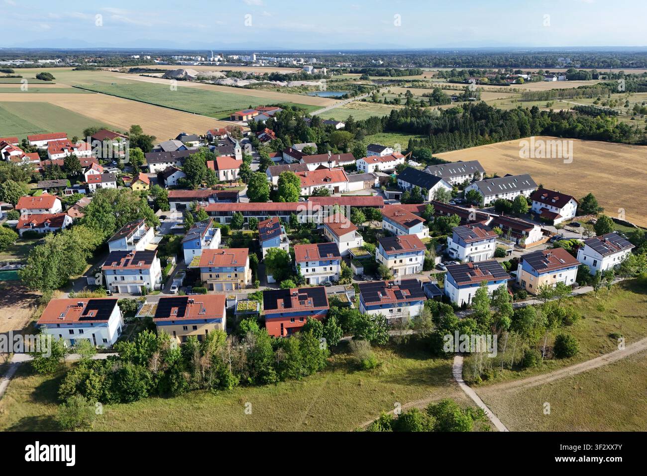 La photographie aérienne montre plusieurs maisons individuelles et maisons jumelées dans un quartier résidentiel moderne avec de grandes installations photovoltaïques sur les toits. Les modules solaires utilisent une grande partie des surfaces des toits pour une production d'énergie durable. Vert Banque D'Images