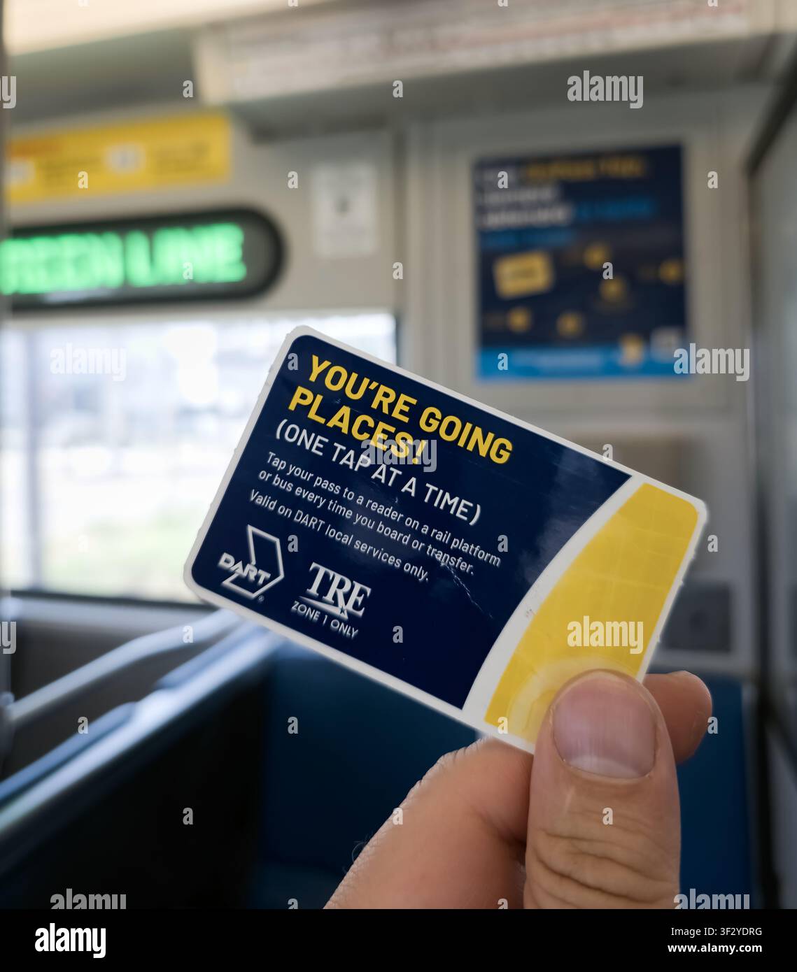 DALLAS, TX, ÉTATS-UNIS - 11 JUIN 2026 : Une main tenant une carte de transit DART et TRE avec le slogan "You're Going Places" à l'intérieur d'un train de métro léger. La carte Banque D'Images