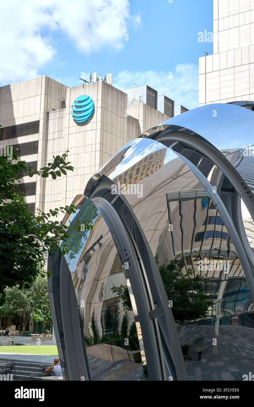 DALLAS, TX, USA - 11 JUILLET 2026 : Une sculpture moderne réfléchissante est vue devant le bâtiment AT and T dans une zone urbaine animée. L'architecture est Banque D'Images
