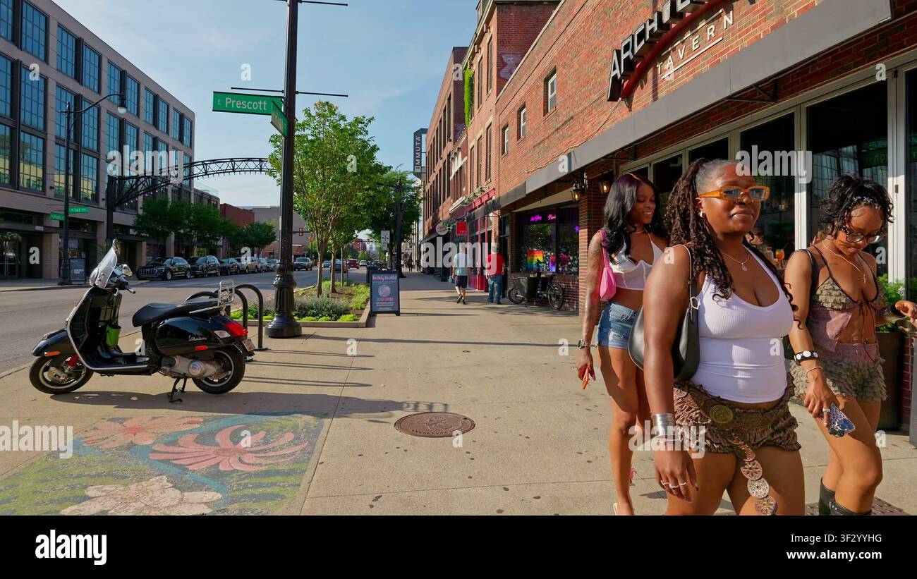 Trois jeunes femmes marchant ensemble le long d'un trottoir ensoleillé dans le quartier des arts Short North de Columbus, Ohio. Banque D'Images