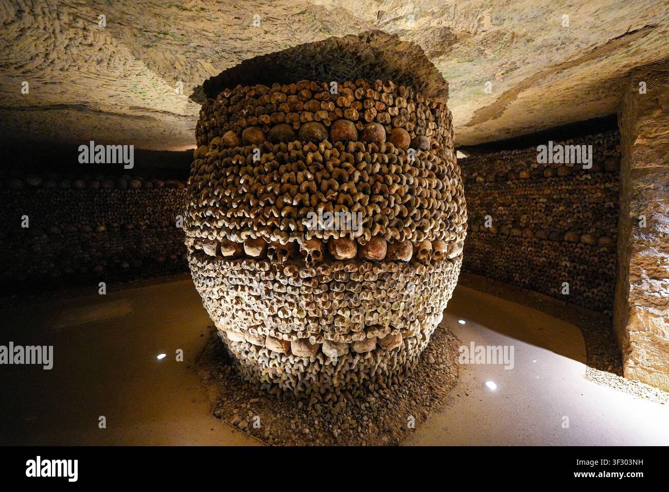 Pillar central en forme de tonneau composé d'os et de crânes humains empilés dans les catacombes de Paris, France Banque D'Images