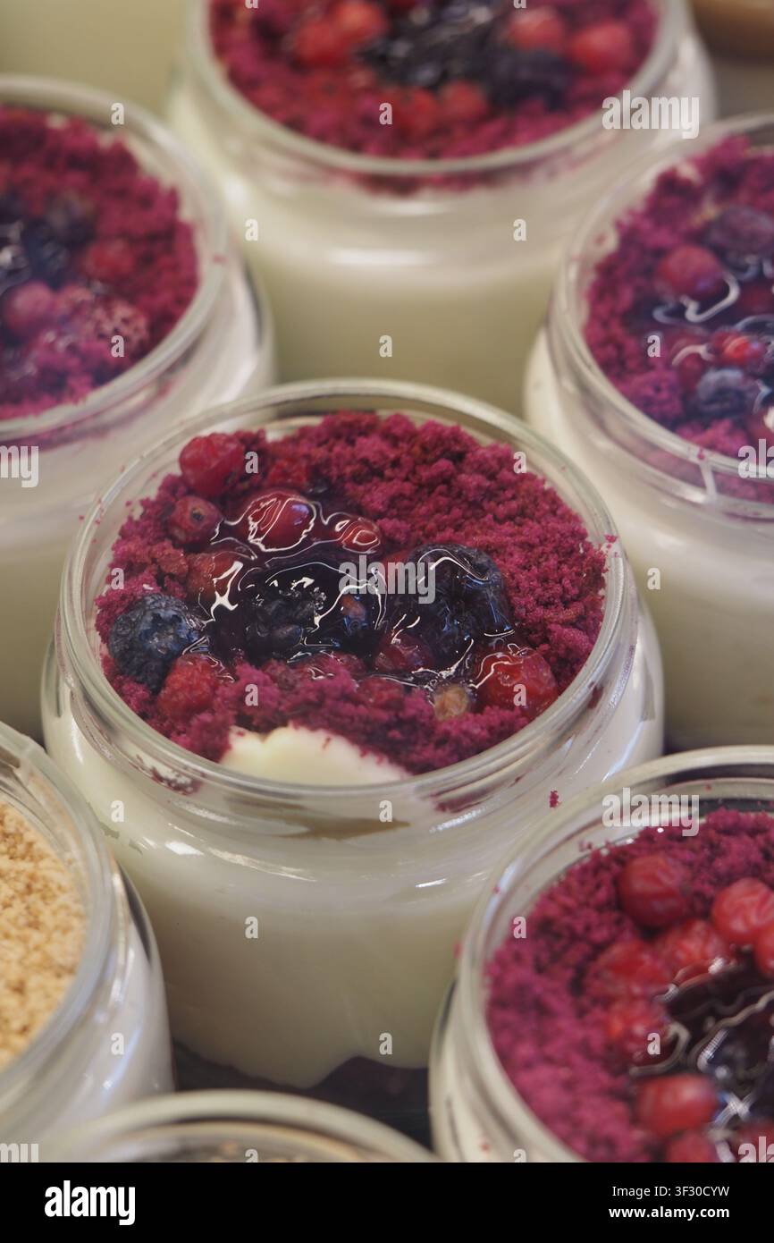Des desserts dans de petits pots avec des fruits et des miettes au sommet Banque D'Images