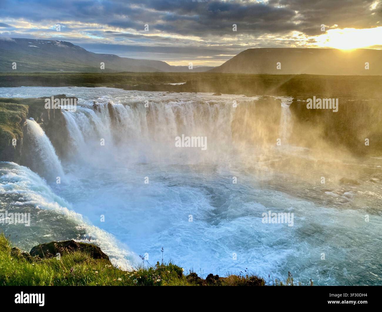 La vue panoramique puissante de la cascade de Goðafoss à l'heure dorée sous un ciel rose, Islande du Nord - Image de stock capturée avec un smartphone