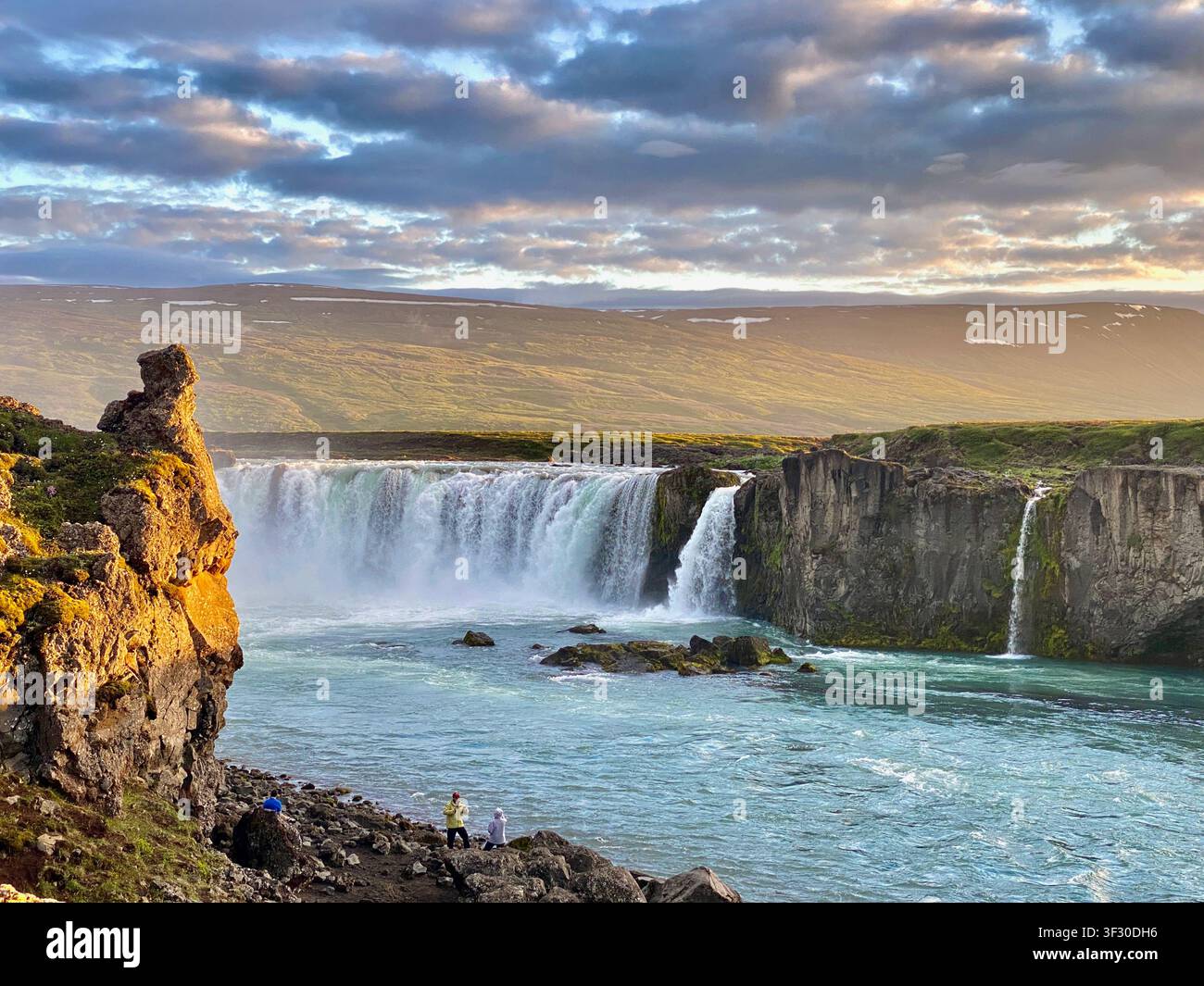 La vue panoramique puissante de la cascade de Goðafoss à l'heure dorée sous un ciel rose, Islande du Nord - Image de stock capturée avec un smartphone