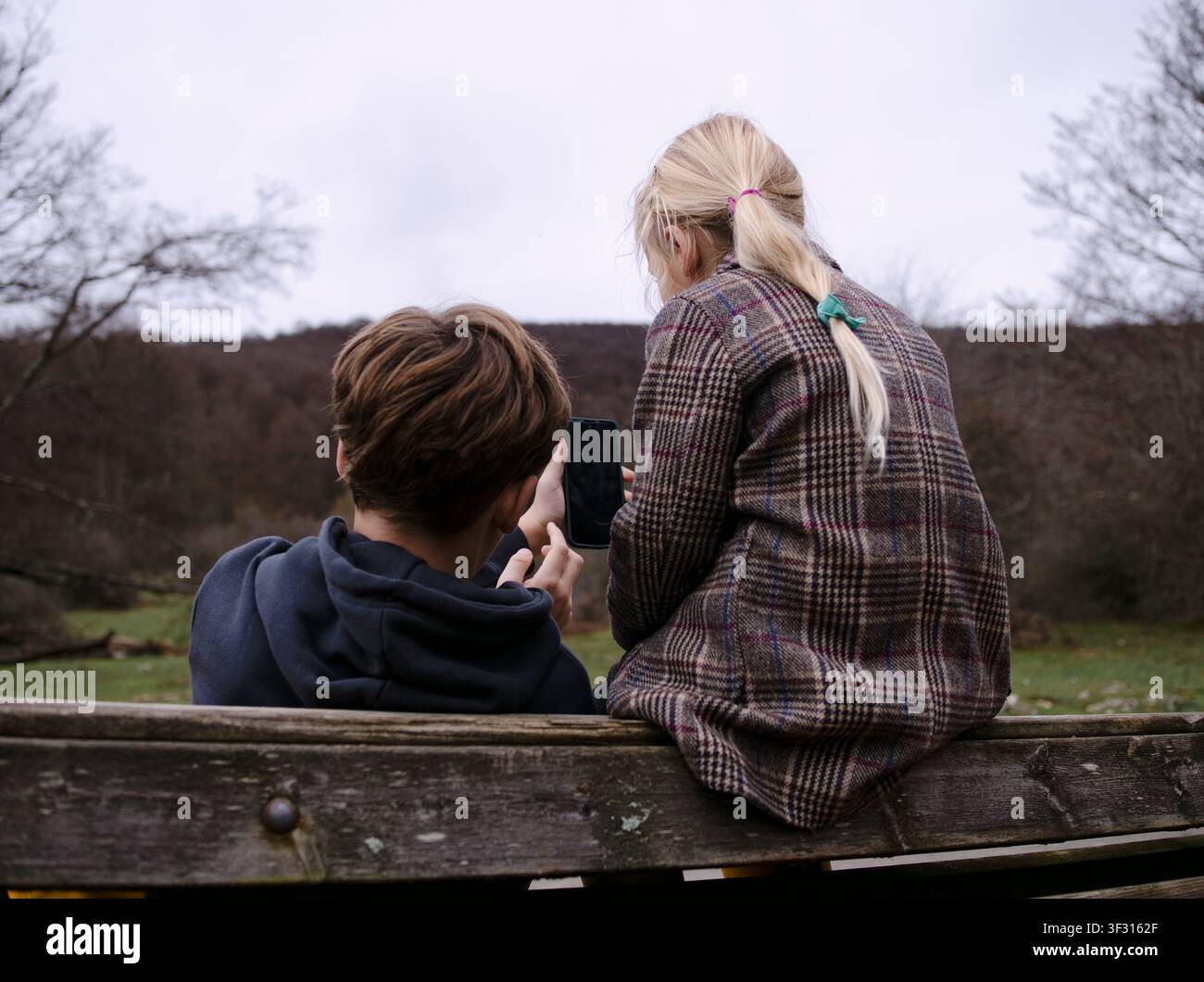 Enfants utilisant un smartphone en plein air dans la nature Banque D'Images