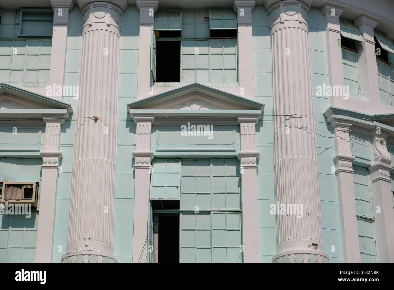 Vue rapprochée de la façade d'un bâtiment colonial historique présentant des colonnes classiques, des frontons décoratifs et des fenêtres traditionnelles à George Town, Penang Banque D'Images