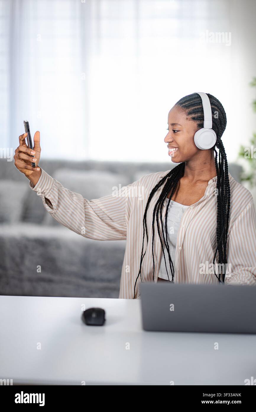 Jeune femme adulte prenant selfie avec un casque et un téléphone Banque D'Images