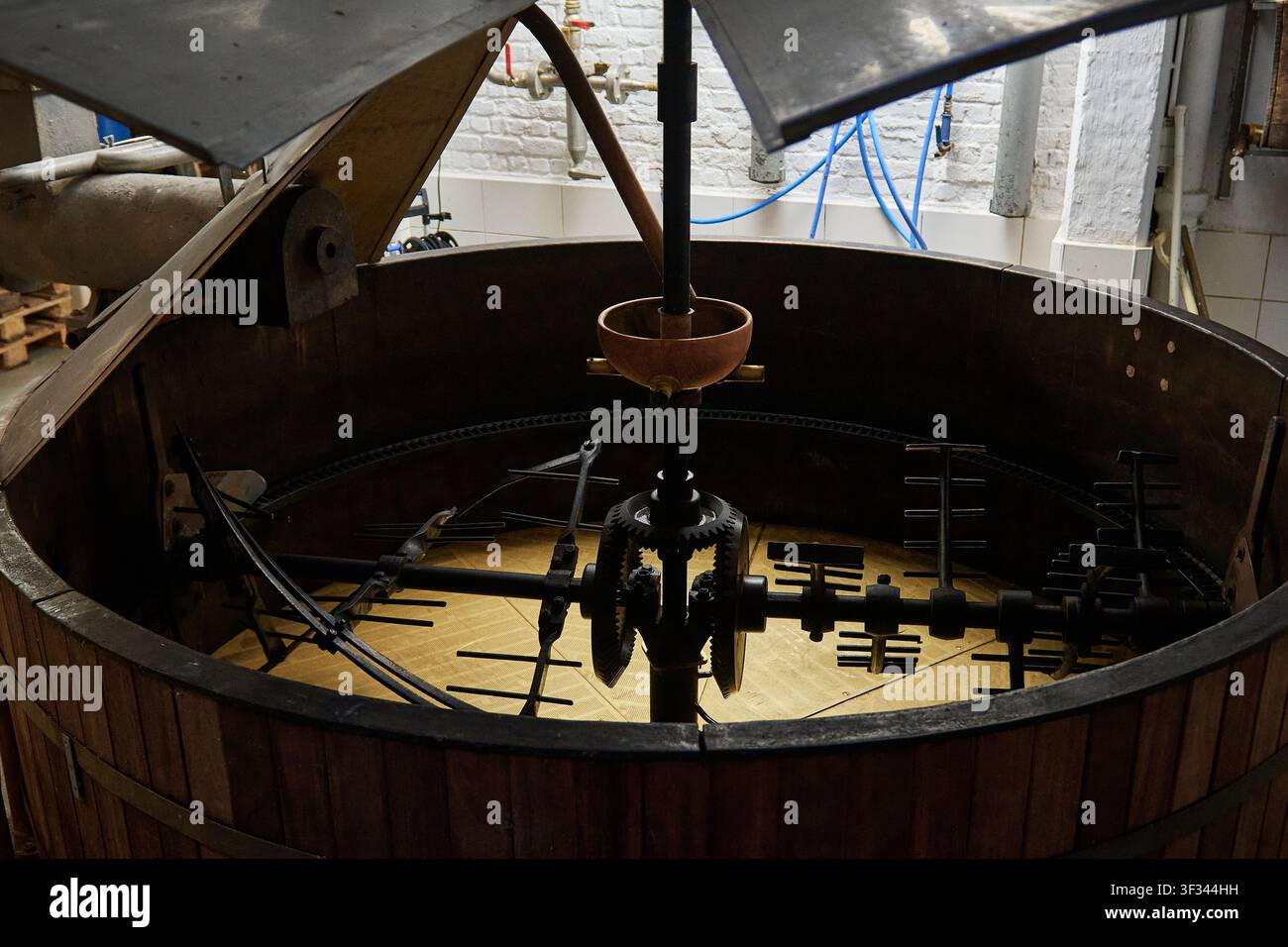 Cuve de brassage ouverte avec engrenages exposés, bras de mélange et couvercles soulevés à l'intérieur de la brasserie Cantillon à Bruxelles, Belgique Banque D'Images