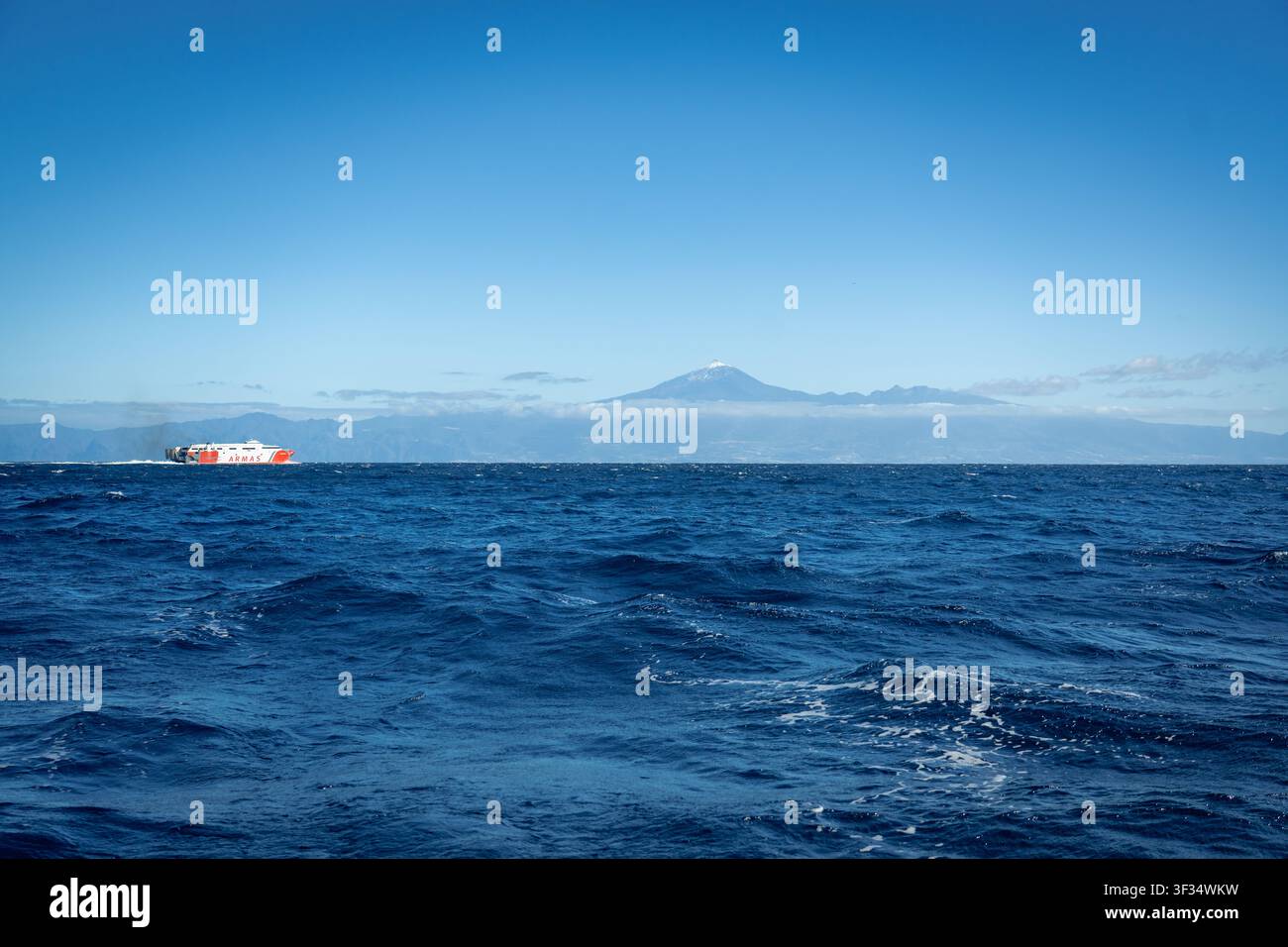 Une navette rapide rouge et blanche de Naviera Armas traverse l'Atlantique bleu profond entre les îles Canaries avec le sommet enneigé du Teide à Tenerife à l'horizon, Espagne, photographiée le 20 janvier 2026. Banque D'Images
