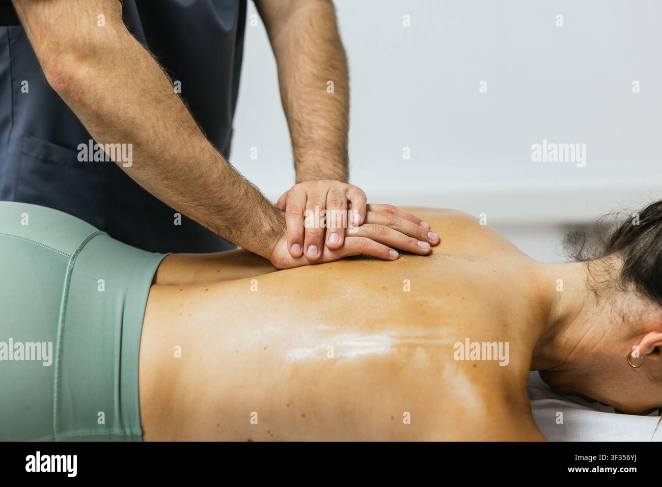 Thérapeute professionnel donnant un massage sportif en profondeur des tissus Banque D'Images