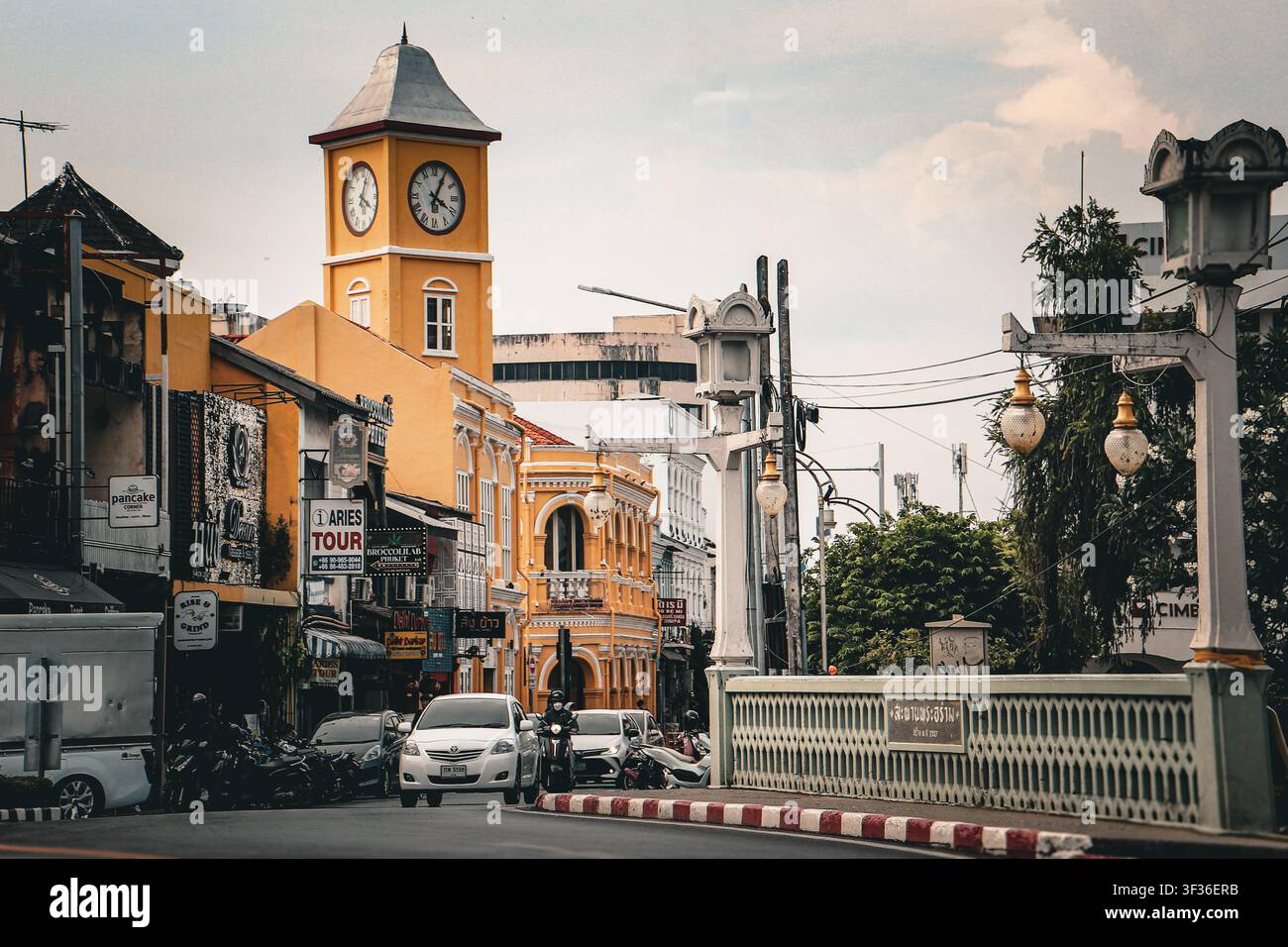 Scène de rue dans la vieille ville de Phuket, Thaïlande, montrant une architecture sino-portugaise traditionnelle, le clocher jaune proéminent de Surin et la circulation locale Banque D'Images