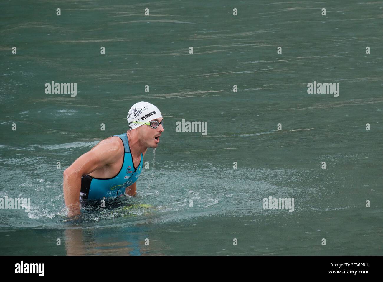 Un compétiteur sort de l'eau lors du Ledro SwimRun Test Day au lac Ledro, en Italie. Les athlètes alternent entre la natation et la course à pied. Banque D'Images