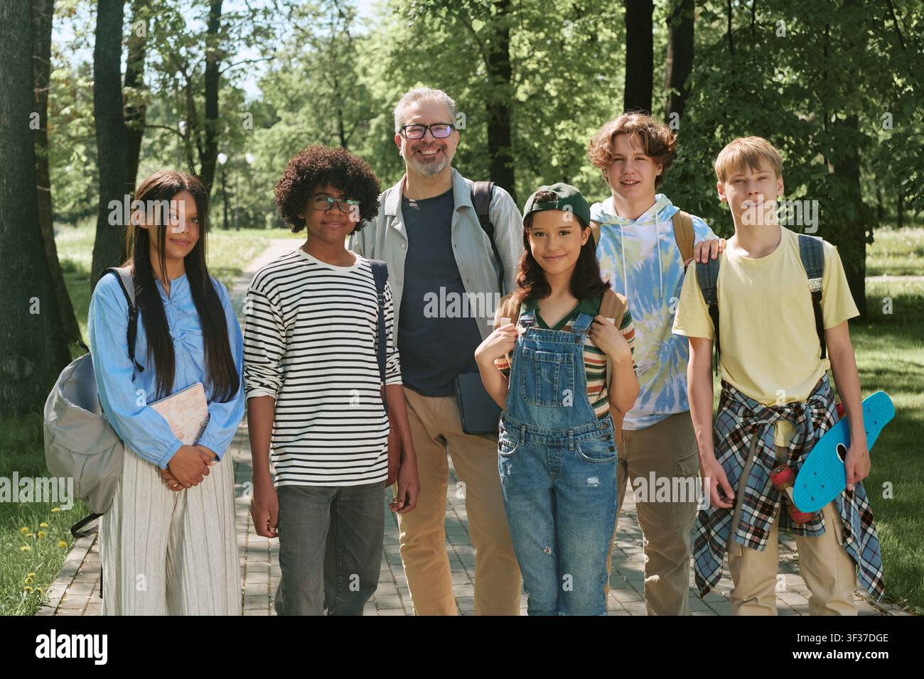 Portrait d'étudiants adolescents divers avec un enseignant masculin dans un parc Banque D'Images