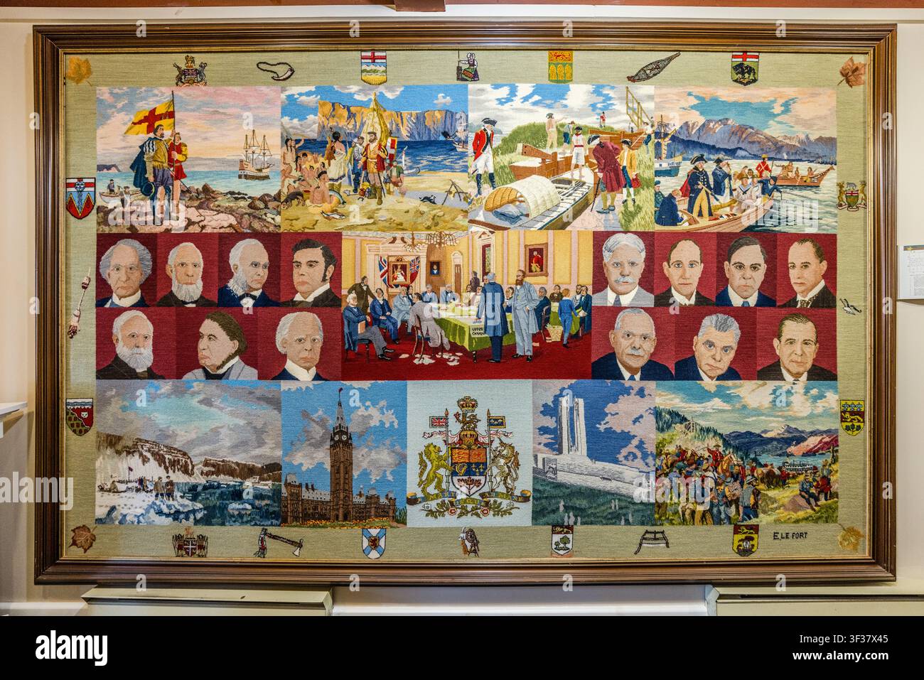 Une tapisserie représentant l'histoire du Canada, mettant en scène les armoiries des provinces, des scènes de l'ère coloniale, des portraits d'hommes d'État, ainsi qu'un mémorial de guerre et la Tour de la Paix aux bâtiments du Parlement à Ottawa – une autre œuvre de l'artiste textile Elizabeth Lefort (1914–2005) dans la collection du centre culturel Les Trois Pignons sur le Cabot Trail à Cheticamp, en Nouvelle-Écosse, Canada. Cheticamp, Nouvelle-Écosse, Canada Banque D'Images