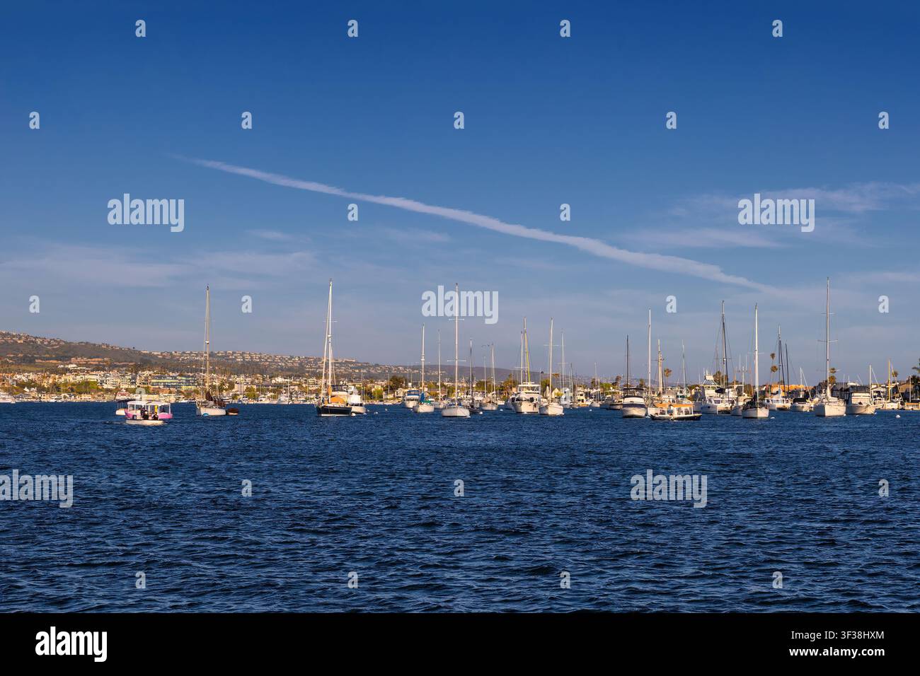 Newport Beach, Californie, États-Unis - 21 juin 2026 : Des bateaux ancrés se trouvent sur l'eau agitée par le vent dans le Newport Harbor à Newport Beach, Californie Banque D'Images