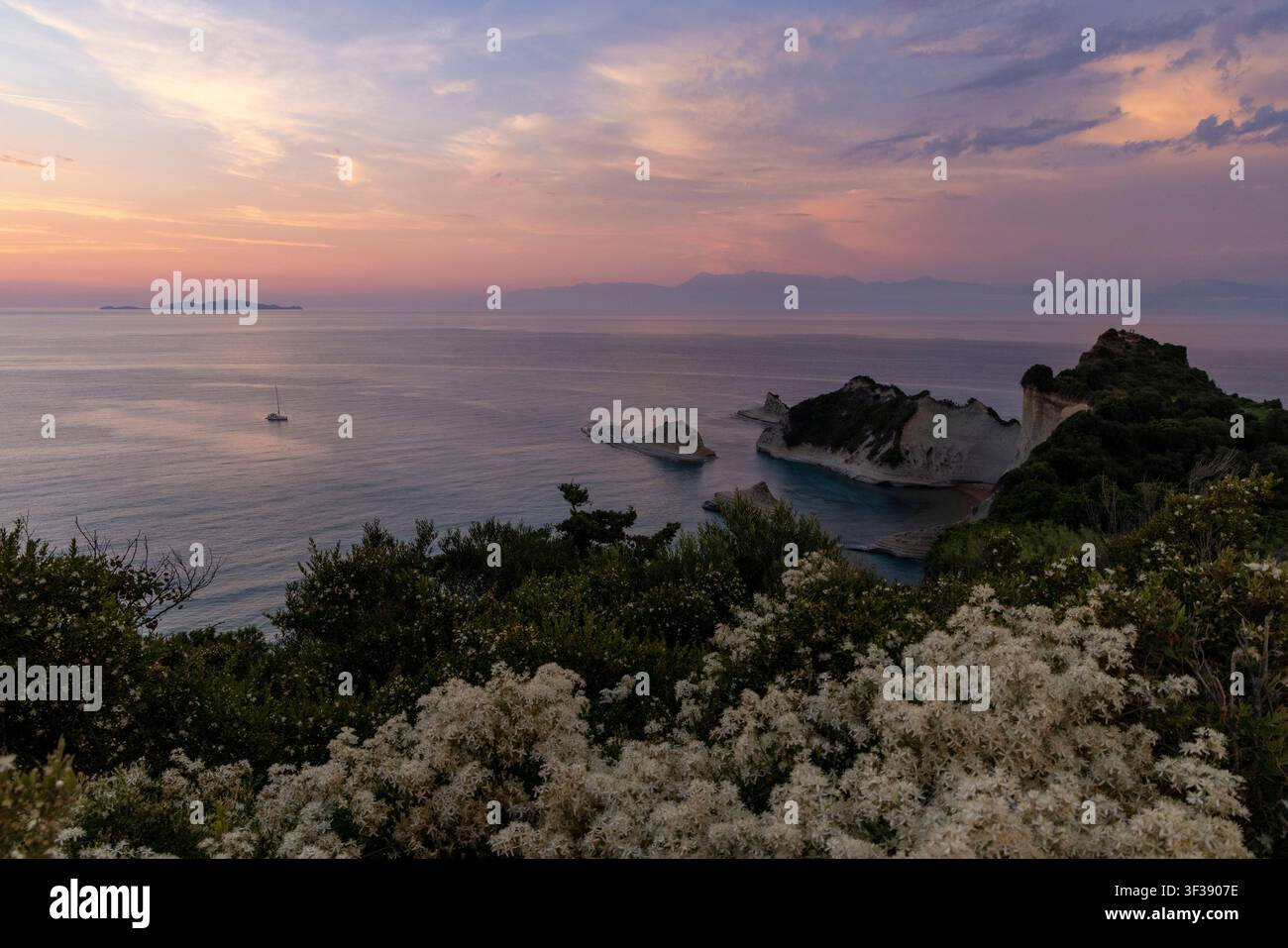 Mer Ionienne et falaises blanches au cap Drastis, île de Corfou, Grèce, recevant les couleurs chaudes d'un ciel de coucher de soleil d'été Banque D'Images