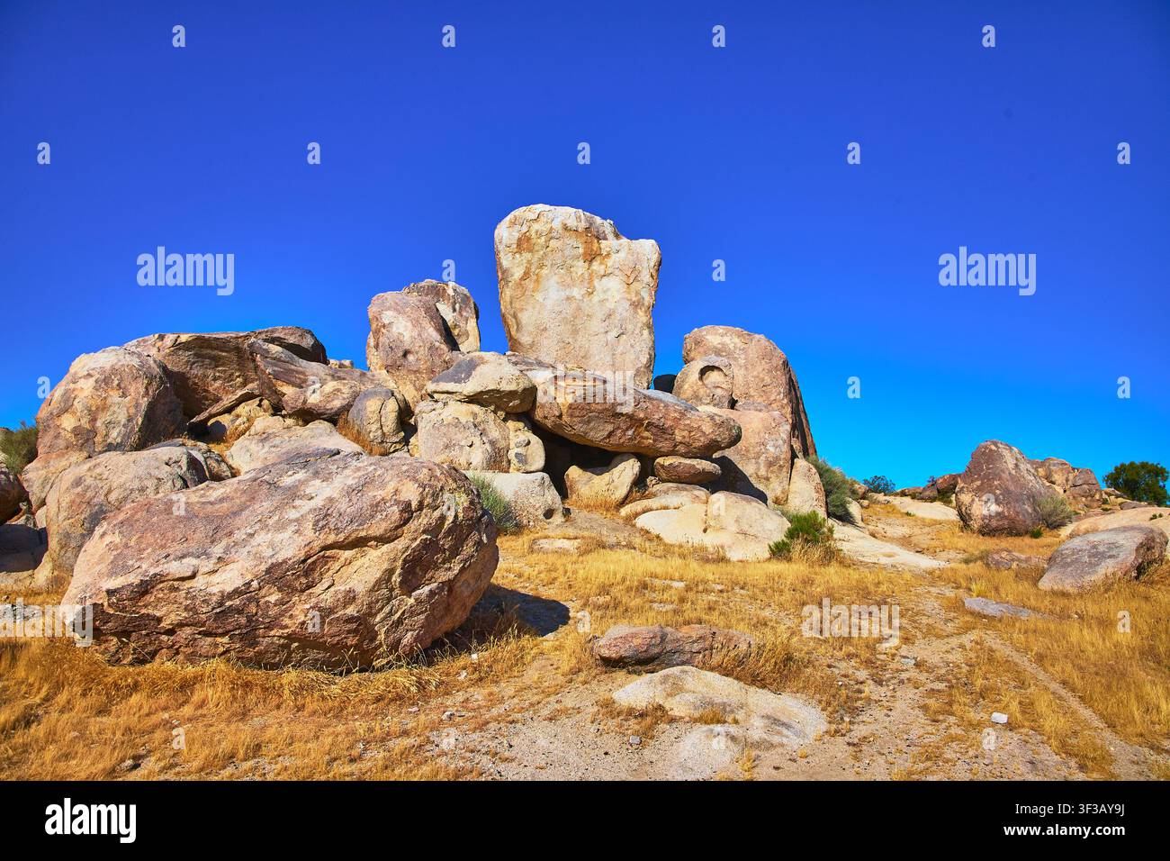 Formations rocheuses massives et paysage désertique sous un ciel bleu éclatant Banque D'Images