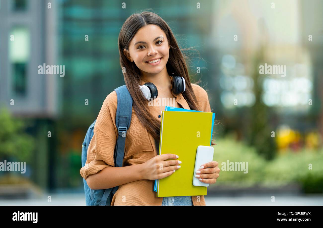 Joyeuse belle femme étudiante posant sur le campus universitaire, espace de copie Banque D'Images