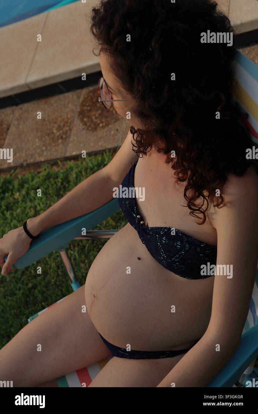 Bien-être en grossesse et confort estival au bord d'une piscine Banque D'Images
