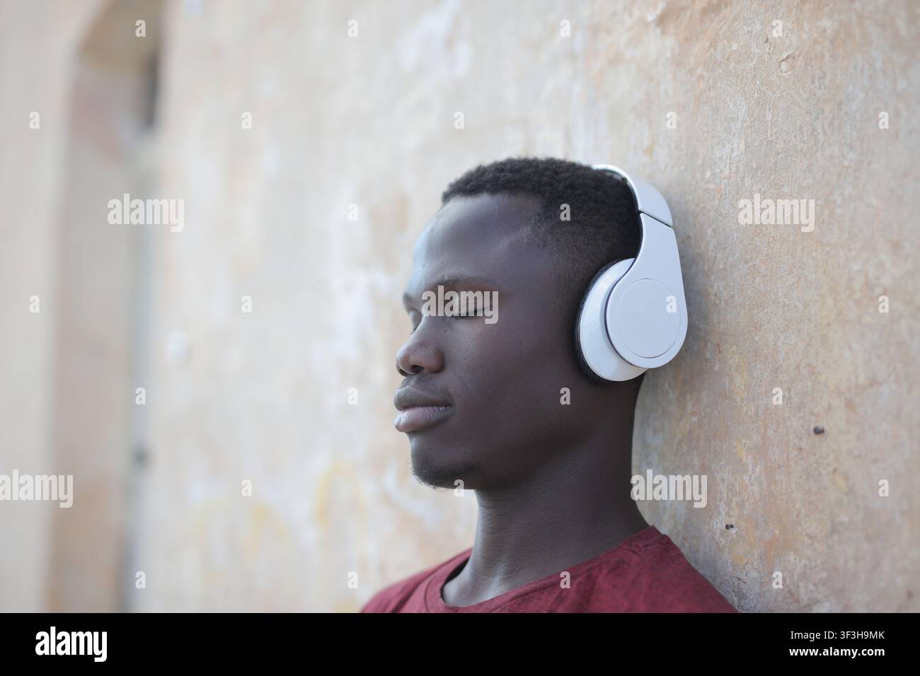 Jeune homme noir les yeux fermés savourant la musique Banque D'Images