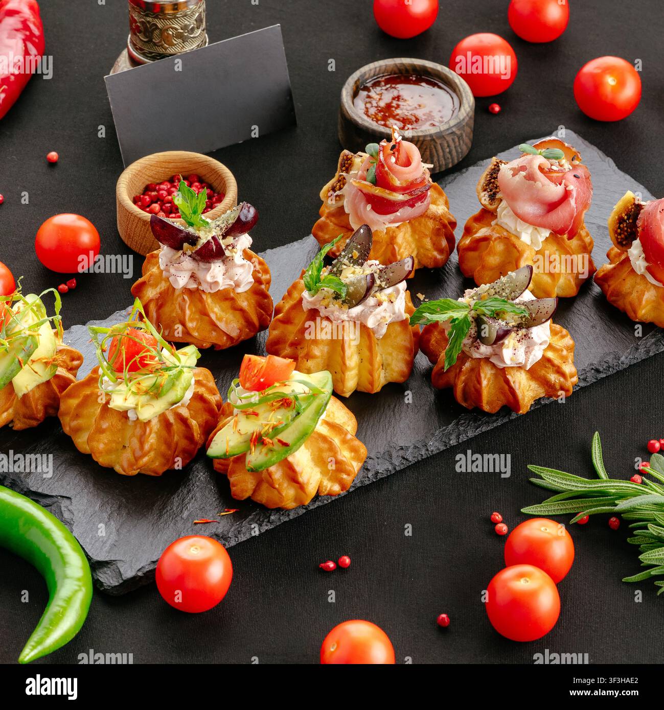 Amuse-bouche gourmet en pâte à choux savoureuse sur ardoise Banque D'Images