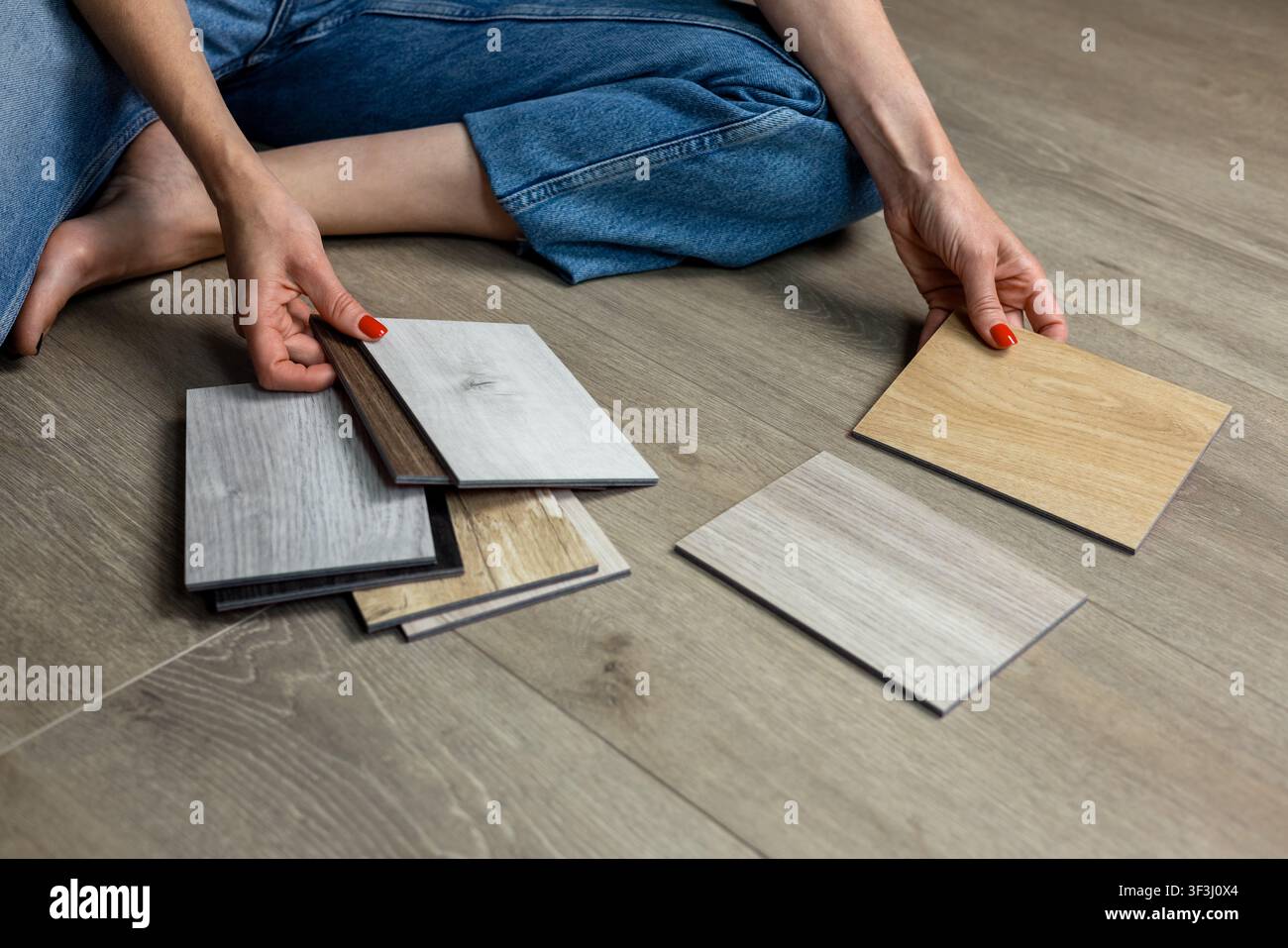 Femme choisissant des échantillons de parquet pour la rénovation de la maison et la décoration intérieure Banque D'Images