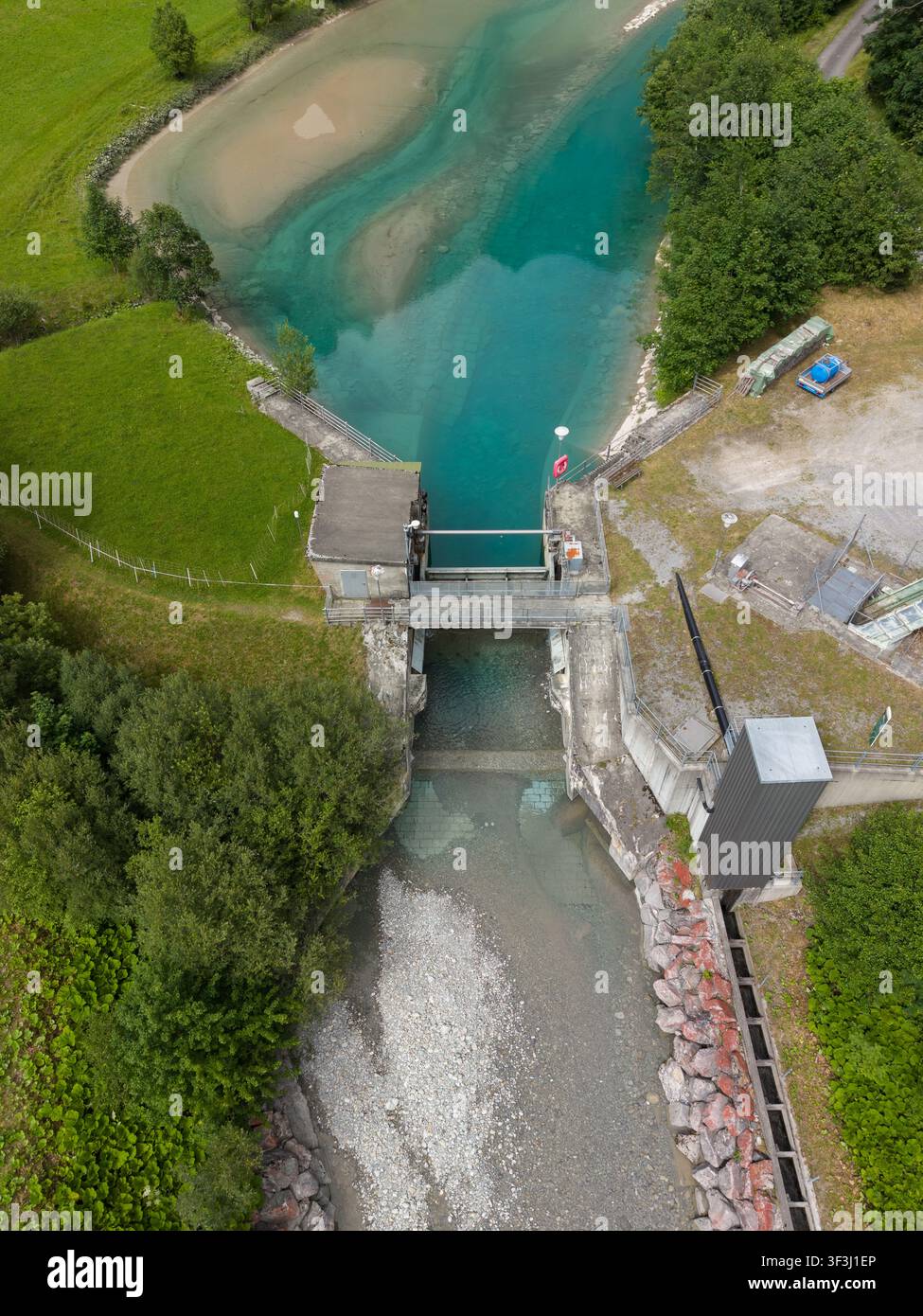 Vue aérienne d'une structure de gestion de l'eau régulant l'eau glaciaire turquoise dans les Alpes suisses près de Gadmen, Suisse. Banque D'Images