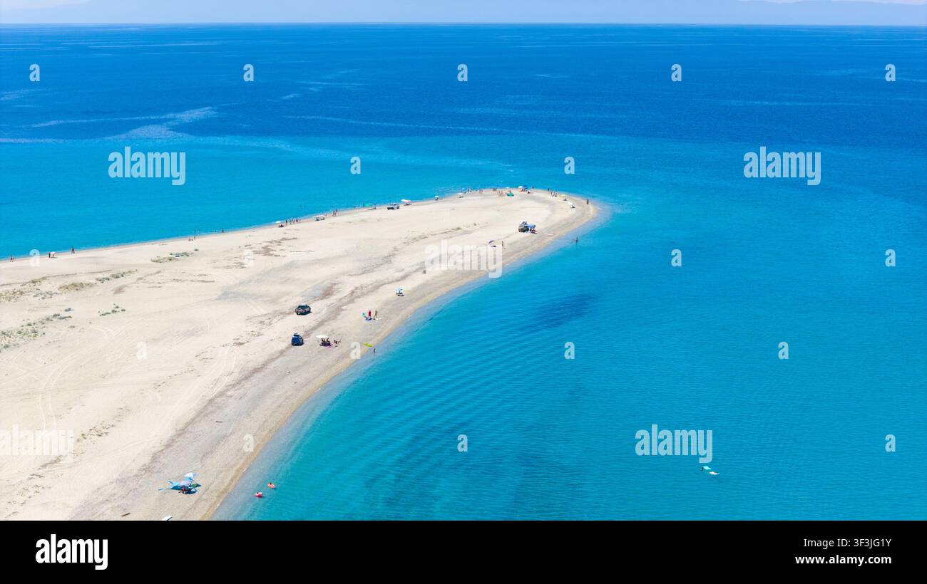 Plage de Possidi, Grèce 11 juillet 2026. Photo de drone montrant des eaux turquoise entourant une longue péninsule de sable avec des visiteurs et des véhicules éparpillés à Po Banque D'Images