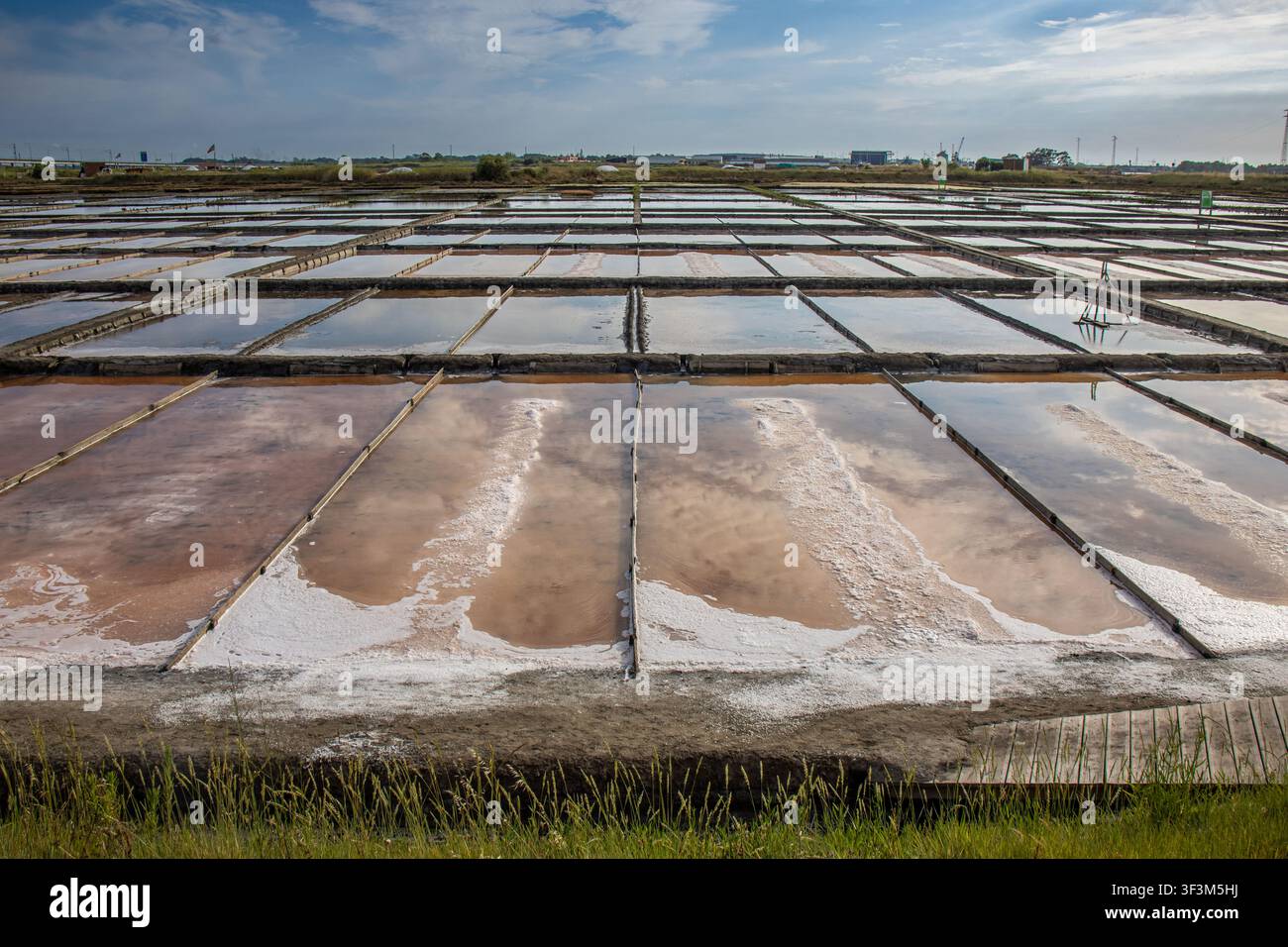 Vue panoramique des salines traditionnelles d'Aveiro, Portugal. Bassins d'évaporation réfléchissants et motifs géométriques. Banque D'Images